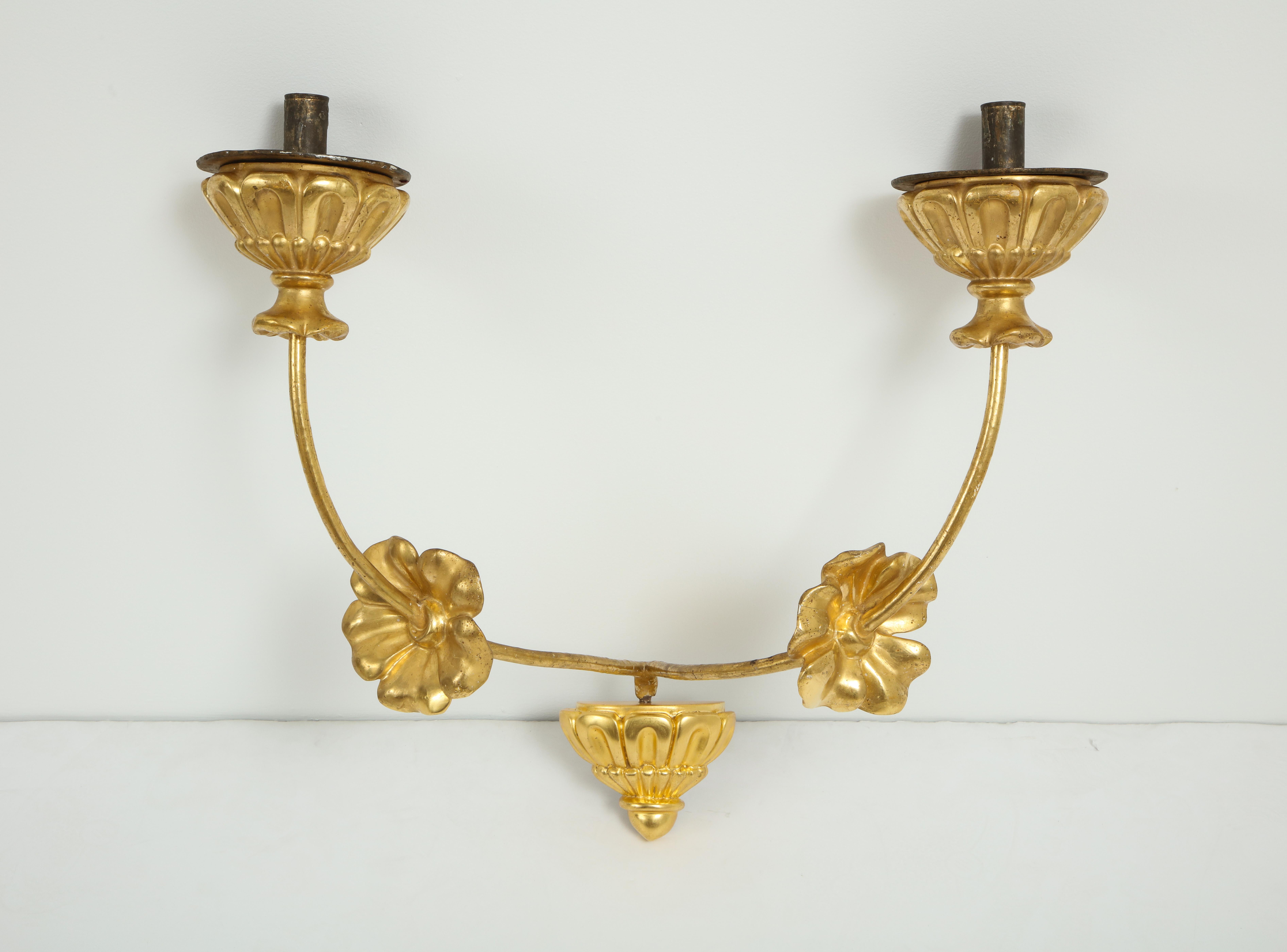 A pair of grand scale neoclassic gilded iron and carved giltwood, two-light wall sconces. The gilded bobeche with acanthus leaf carving; the elegant arms decorated with gilded carved flowers (The base brackets later). Not electrified.
Italy, circa