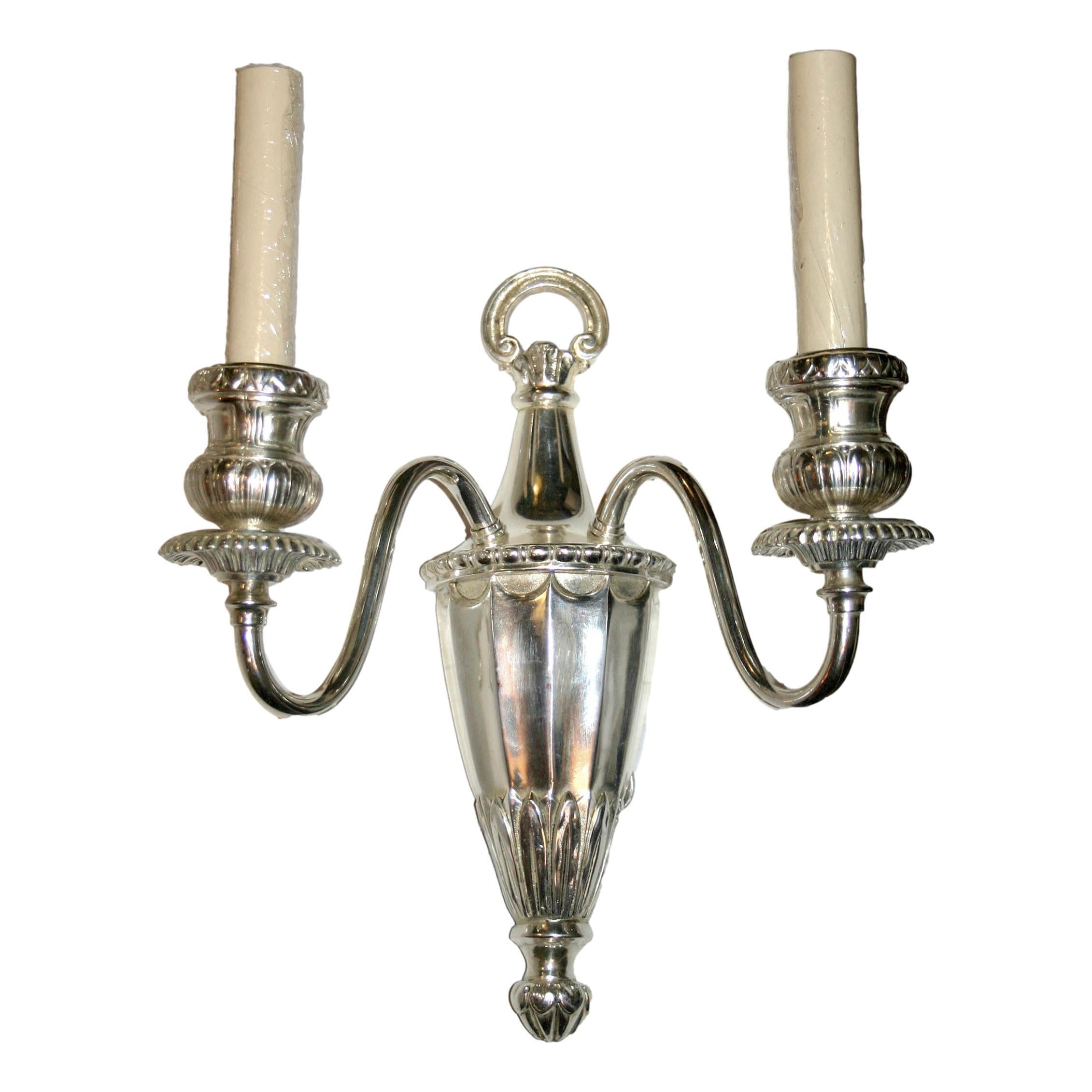 Pair of circa 1920's American two-arm neoclassic style silver-plated sconces.

Measurements:
Height: 14