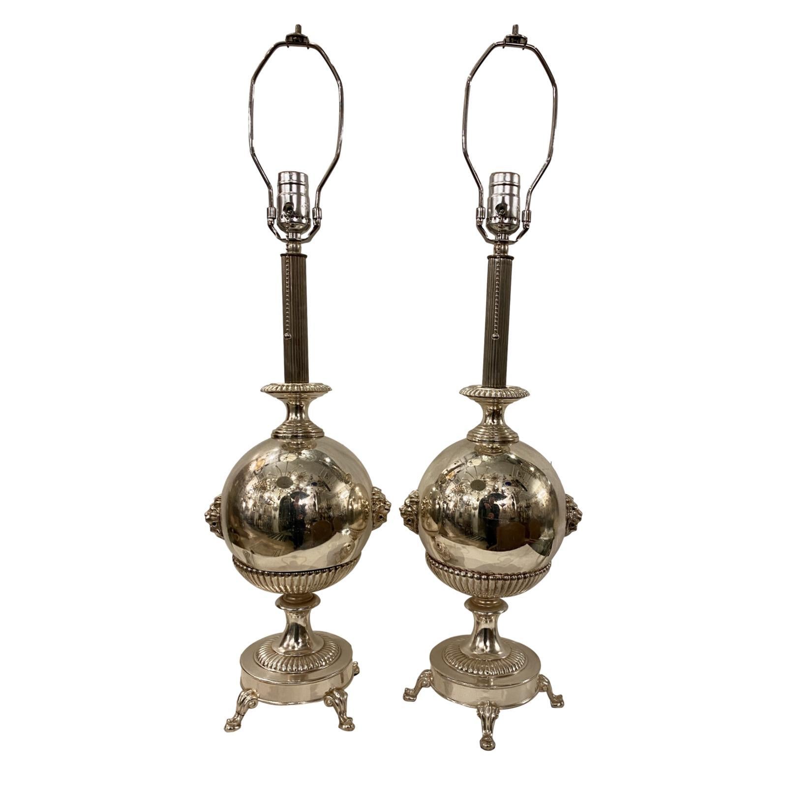Pair of circa 1920's silver-plated neoclassic style lamps of neoclassic style, with lion's heads on body.

Measurements: 
Height of body: 20