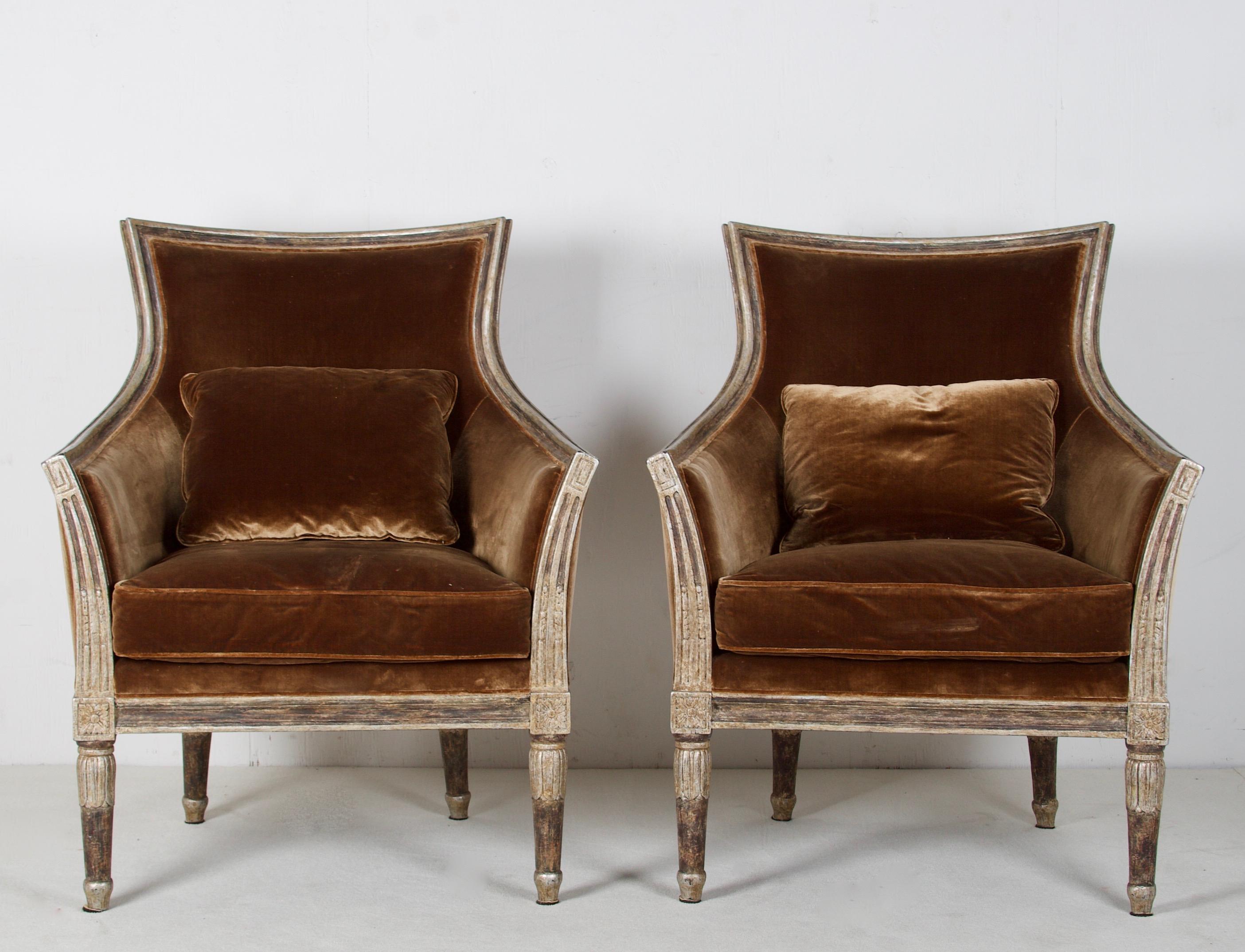A fine pair of neoclassic style reproduction chairs, upholstered in lovely silk velvet.
The chairs have a painted and white gold water-gilded finish, which is distessed and glazed to appear old. The seat is deep and comfortable. The silk velvet is