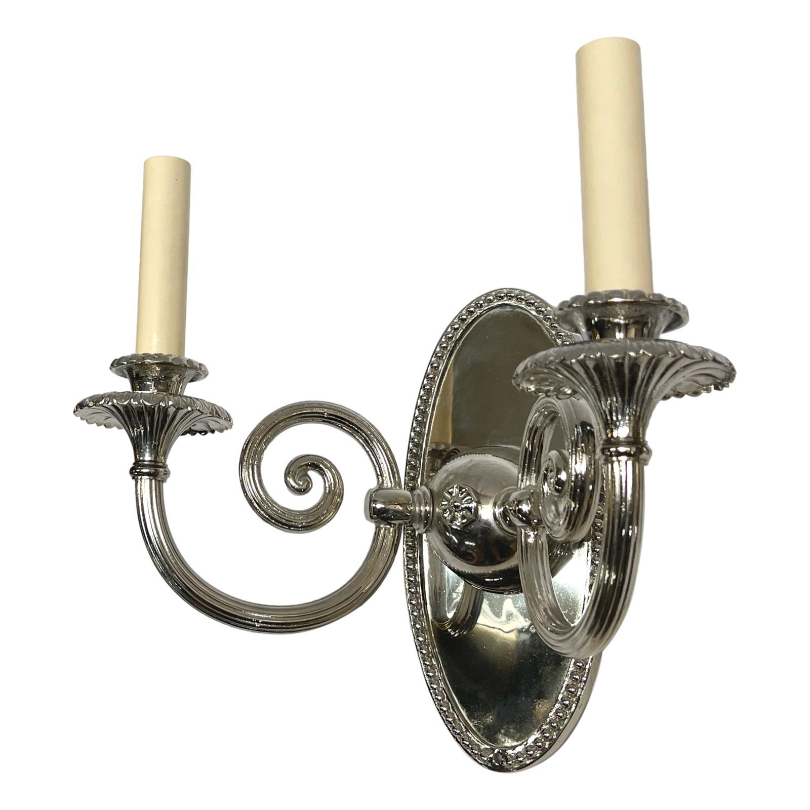 Pair of circa 1920’s French silver-plated two-light sconces.

Measurements:
Height: 10?
Width: 12?
Depth: 7?.