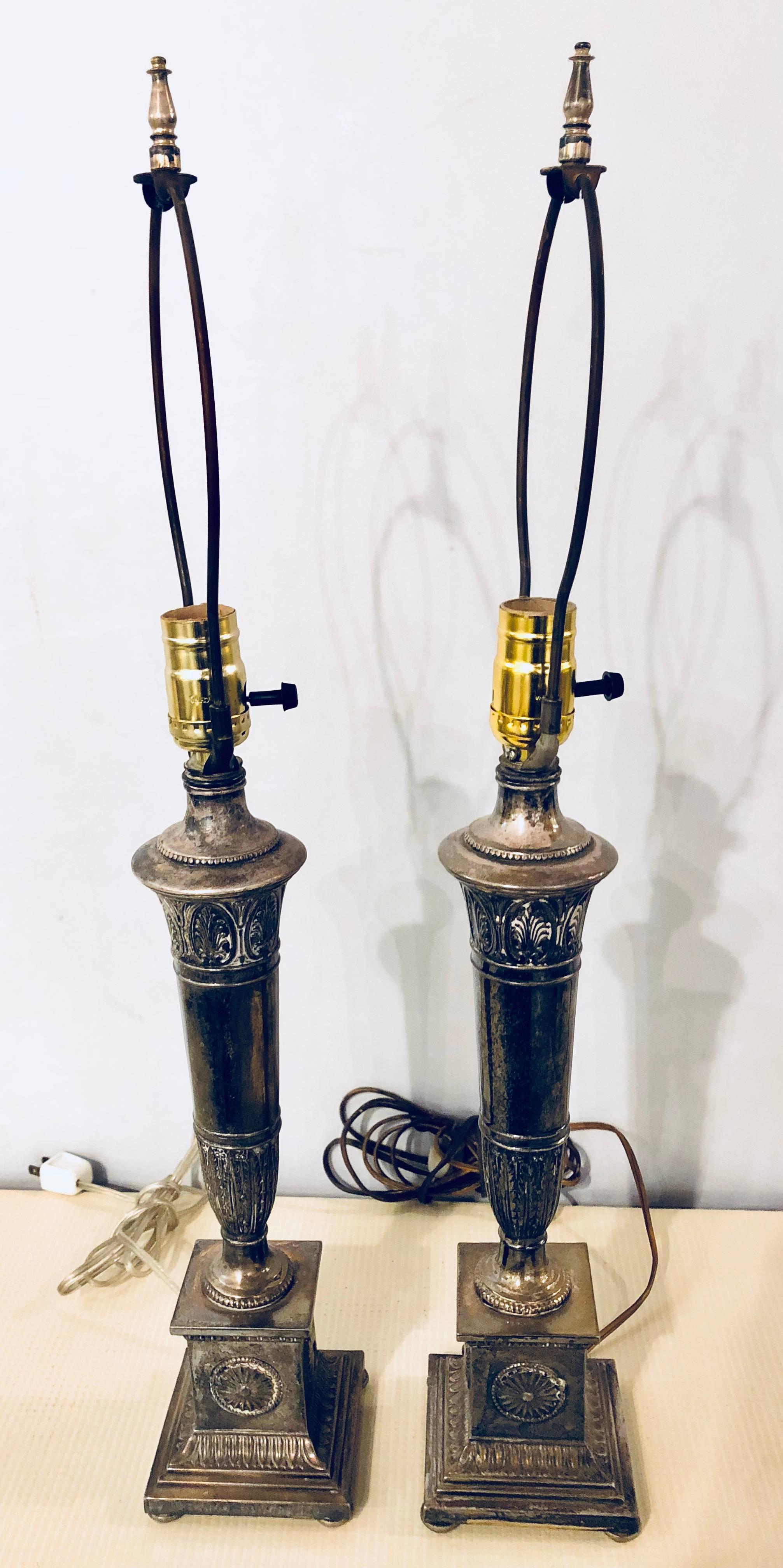 Pair of neoclassic style silvered metal lamps with custom metal shades. These antique table lamps are wonderfully patinated silver plated lamps can easily be cleaned to have a fine silver shine.