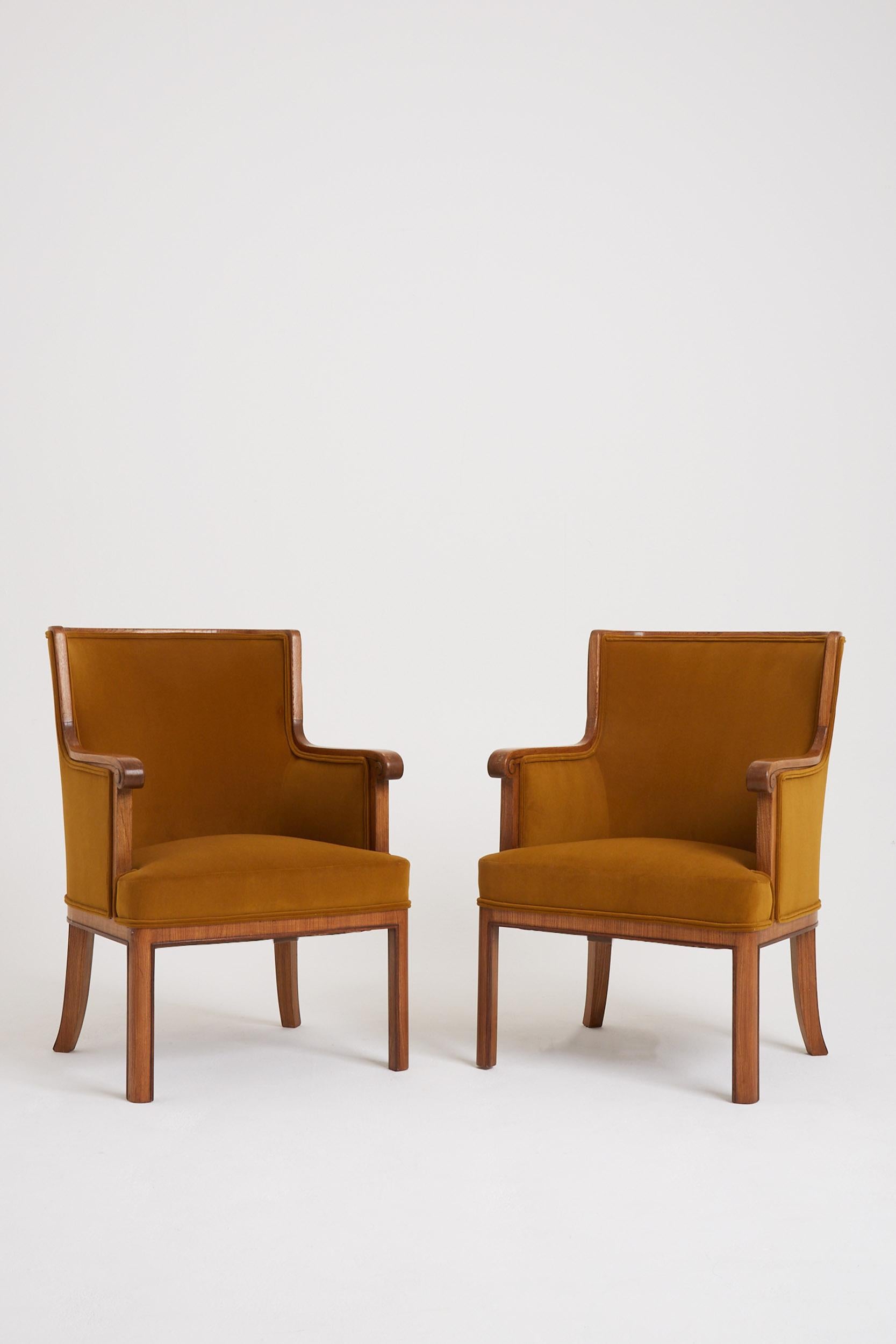 A pair of neoclassical two-tone oak armchairs.
France, Circa 1940.