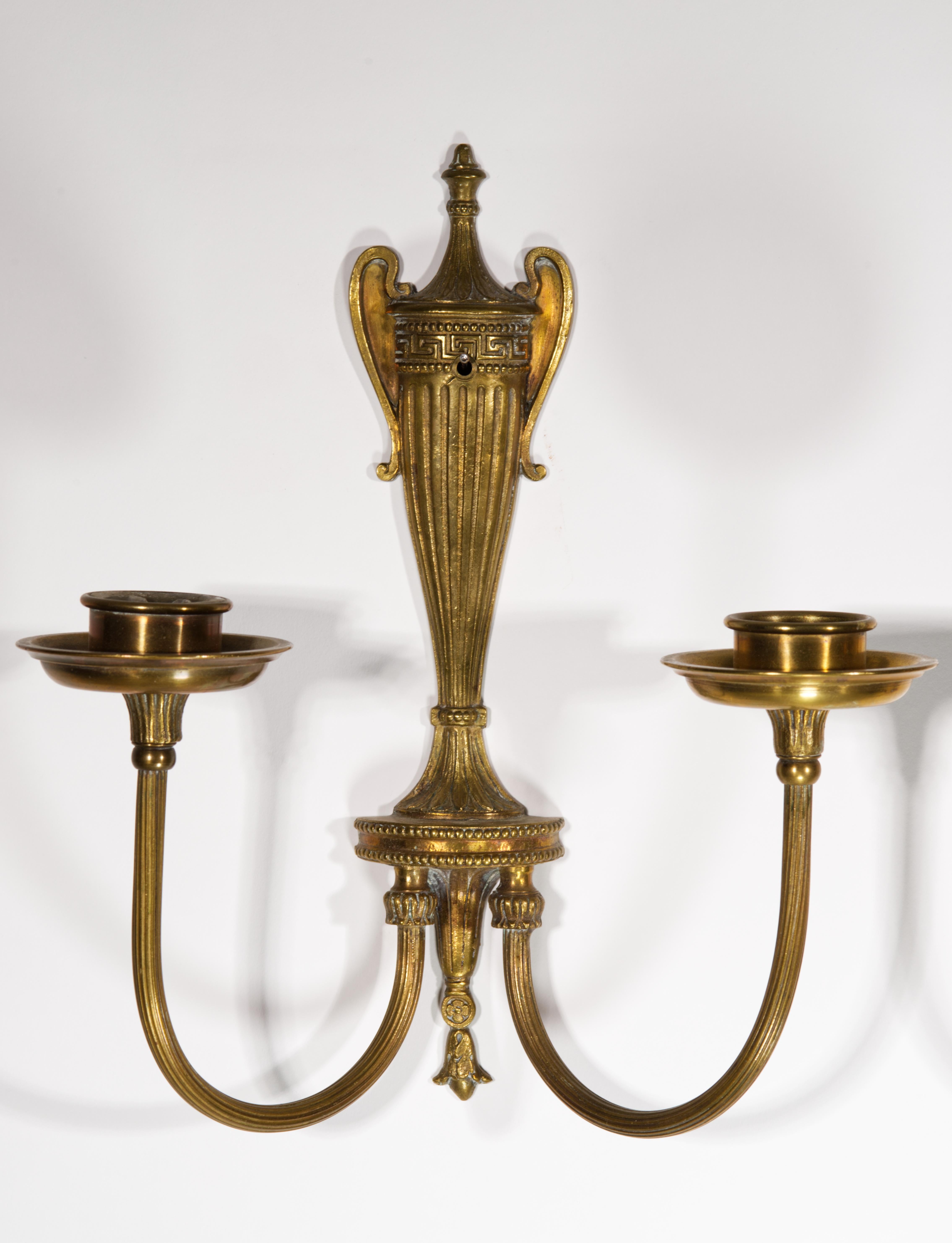 The pair of highly detailed, fine  bronze Neoclassical wall sconces feature large urn decor at the center, with textured curved arms raising from the urn base and ending with wide bobeches.

The sconces can be wired, as the arms appear to be hollow