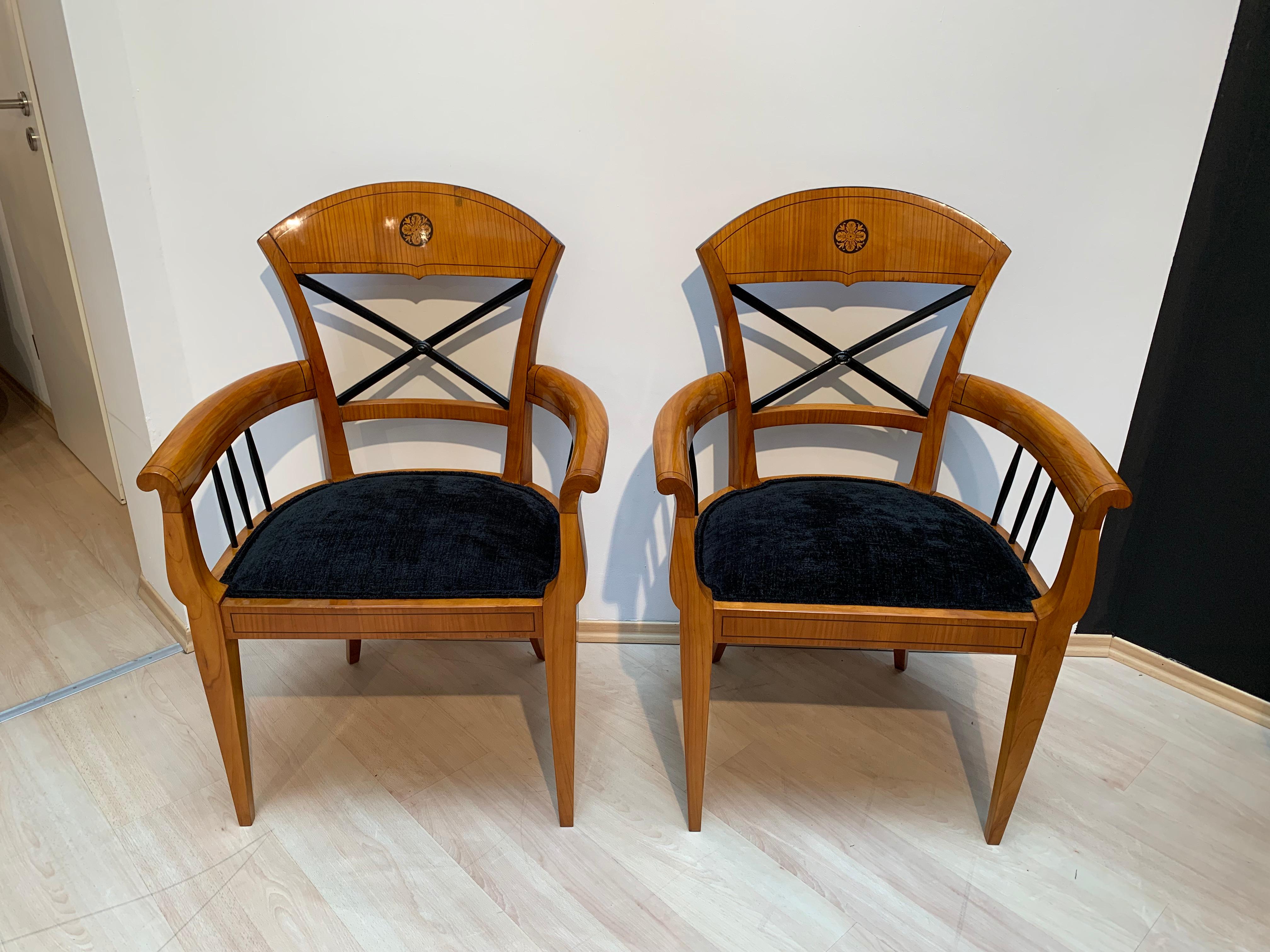 Lovely original pair of restored neoclassical Biedermeier Armchairs from Austria about 1900. 

Bright cherry veneer and solid wood, french polished with shellac by hand. Ebony band inlays on the frame and shield in the backrest. Ebonized cross in