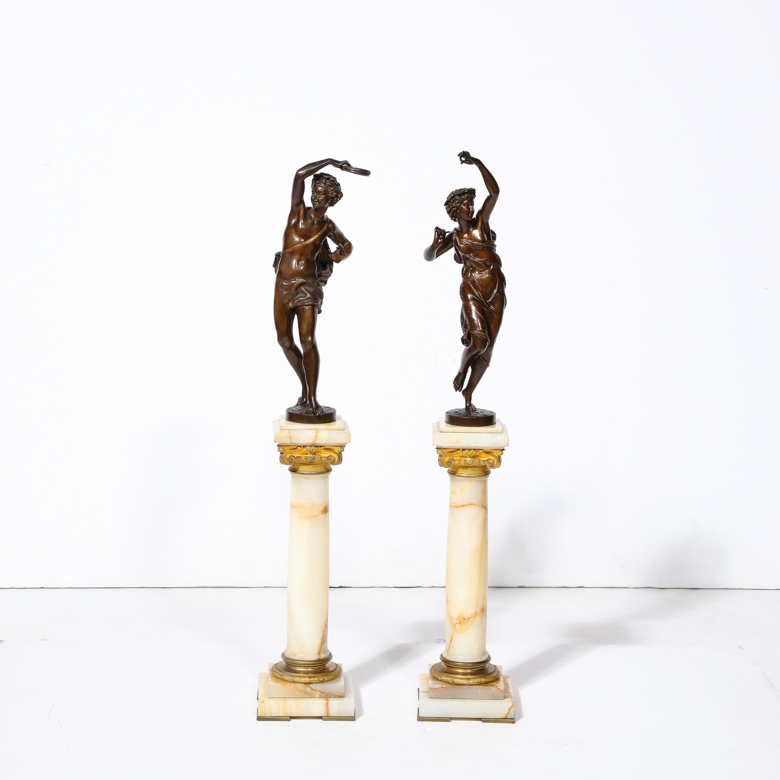 This charming pair of Neoclassical Bronze Bacchantes sculptures by Earnest Rancoulet originate from France, Circa 1900. These young and playful mythological figures are followers of Dionysus, engaging in rituals of dance and exuberance while clothed