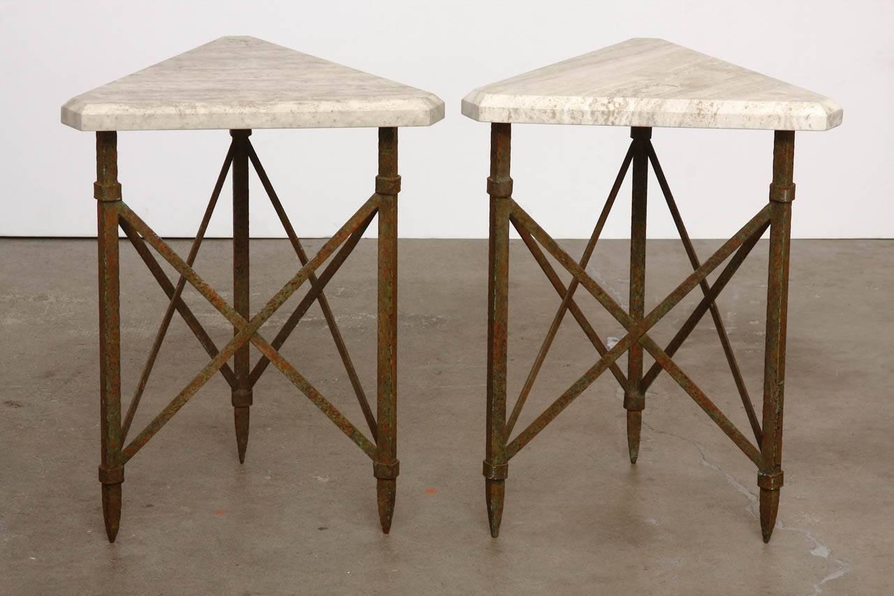 Magnificent pair of bronze and travertine drink tables made in the neoclassical taste featuring x-form bases. Each table base is topped with a thick triangle of smooth honed travertine with a bevelled edge. The bases were constructed from solid