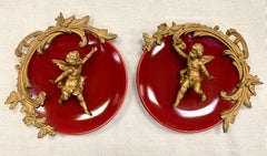 Pair of Neoclassical Bronze Putti on Red Porcelain Plates Plaques Wall Decor