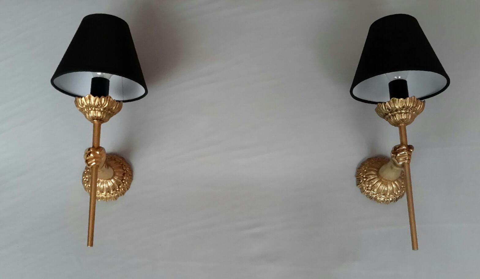Beautiful pair of neoclassical style gilted bronze sconces by Maison Lancel from the 60s representing hands holding a torch.
The pair is in a very good condition, the electrical wiring and parts has been redone and is in compliance with US