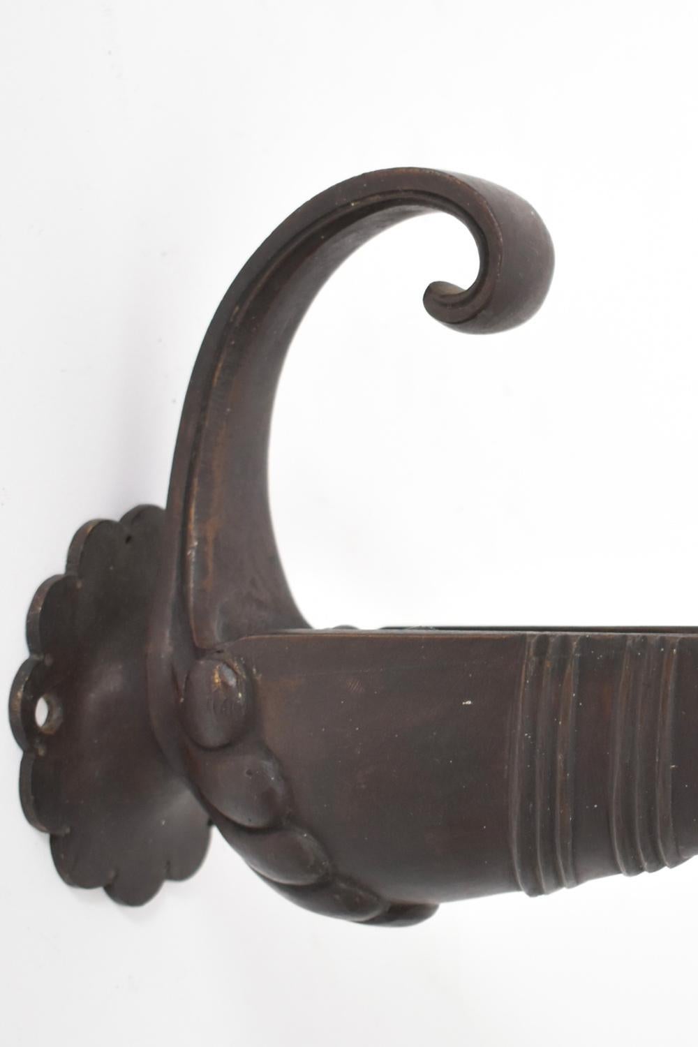 Coppia di appliques in bronzo patinato, in stile antico, con forma anatomica che termina a onda e imita le lampade a olio. Francia, anni '20.