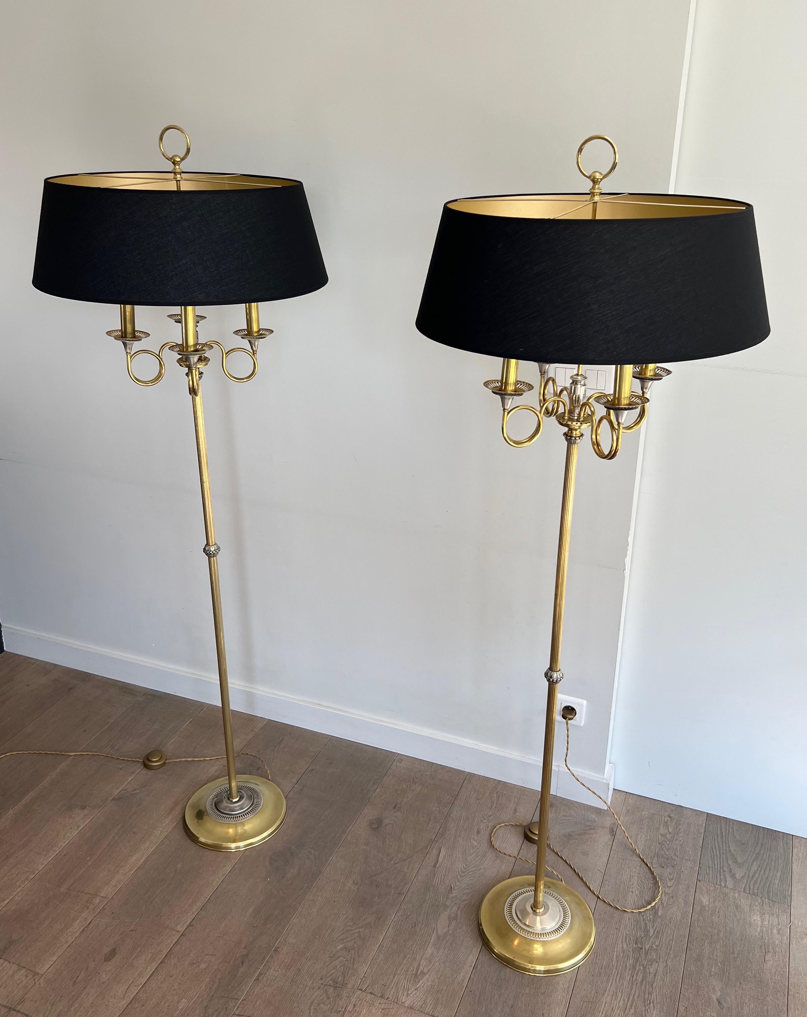 Cette très belle et inhabituelle paire de lampadaires de style néoclassique est faite d'acier brossé et de laiton avec des cornes de chasse. Il s'agit d'un ouvrage français dans le style de la Maison Charles. Circa 1940