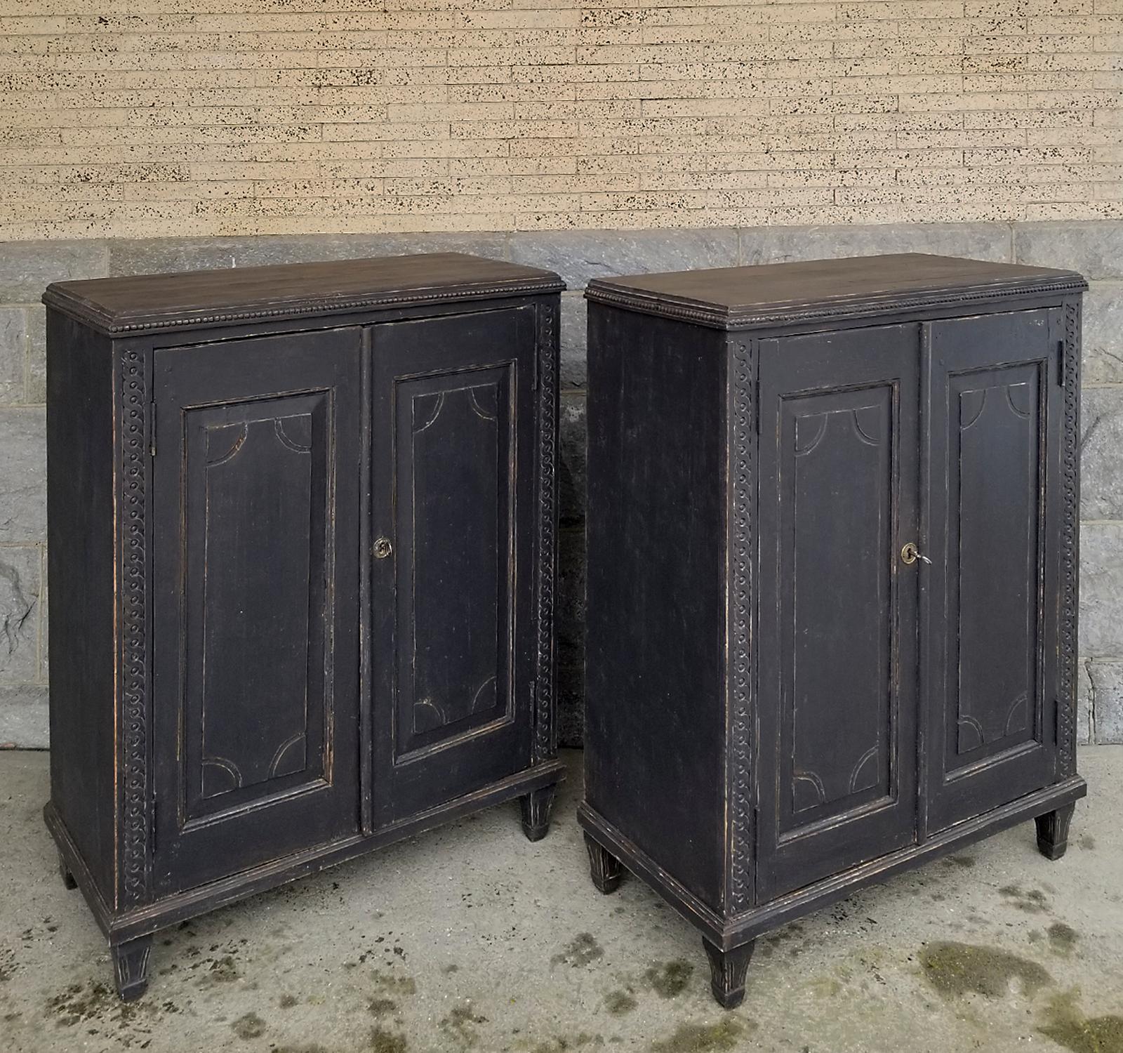 Pair of Swedish half-height cabinets, circa 1840 and perfect for use as sideboards. Each has a pair of raised panel doors with incised detail, guilloche carvings at the sides and beading around the tops. Inside are two fixed shelves. Tapering,