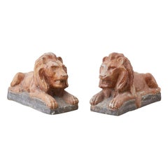 Paire de sculptures de lion couché néoclassiques en pierre coulée