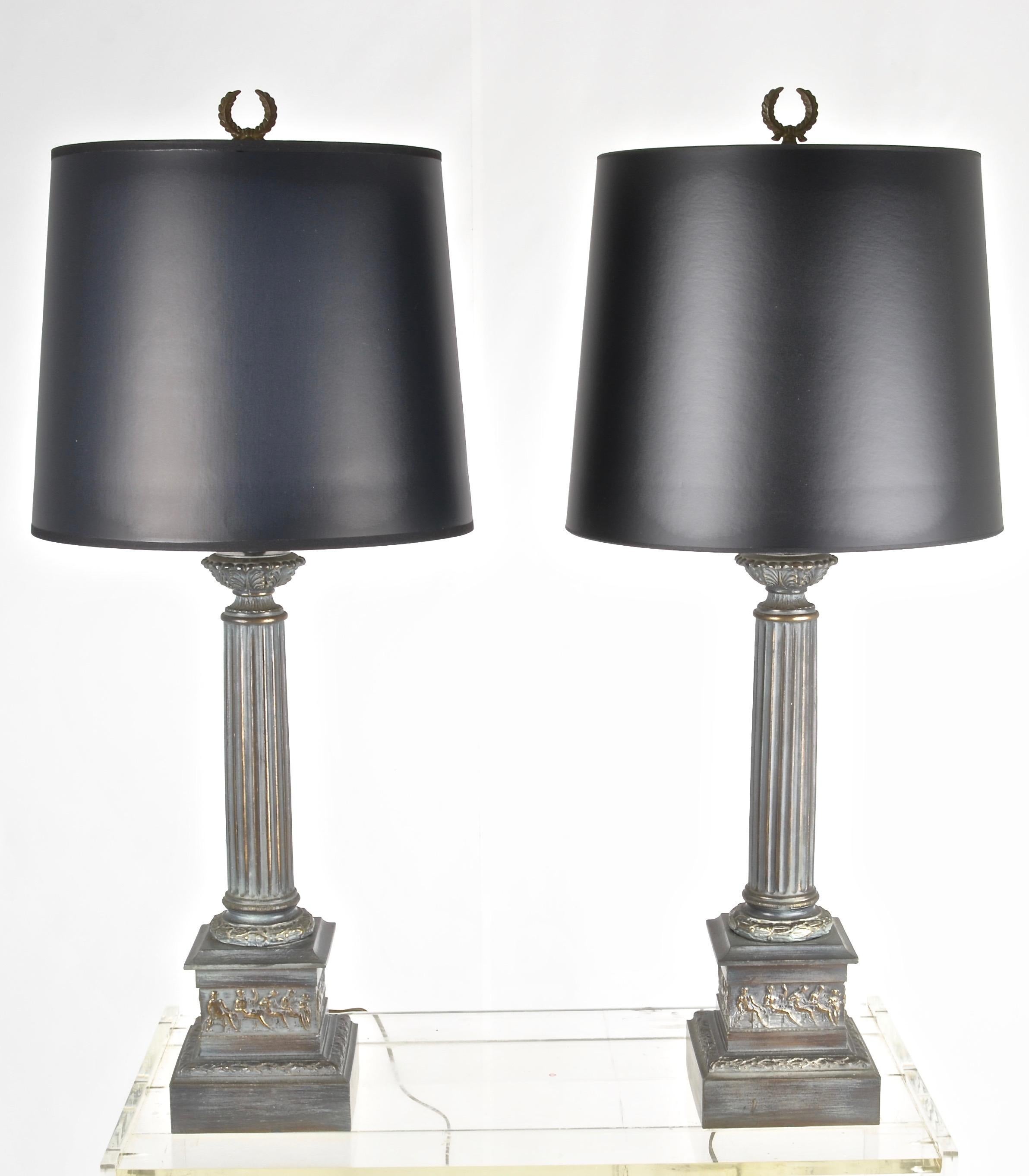 A handsome pair of metal lamps, featuring a neoclassical motif in a verdigris bronze finish. All new wiring and three-way sockets in bronze tone. New shades opaque black paper. Height to the top of the socket is 24.5 inches; to the top of the finial