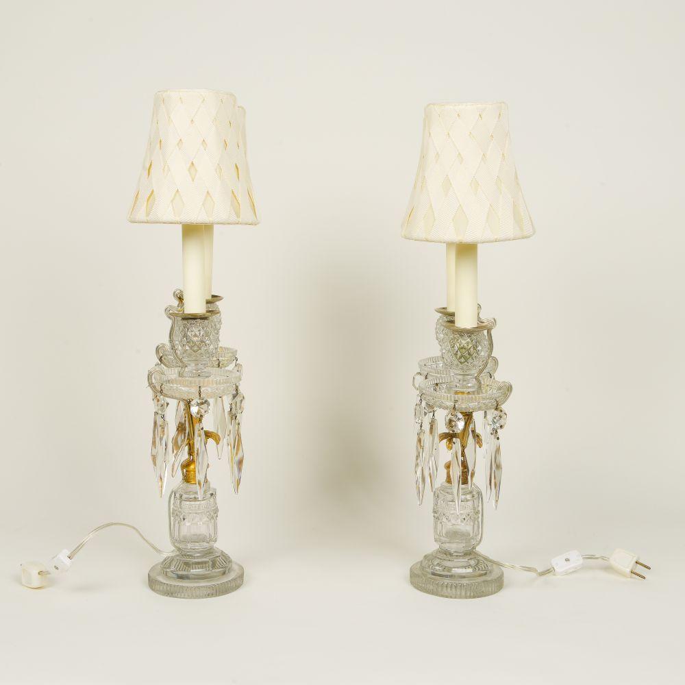 Each with cut crystal support mounted with a gilt-metal outward scrolling candleholders with cut-crystal nozzle and drip-pan with pendant lusters; now electrified and fitted with candle sleeves; with ivory grosgrain ribbon shades.