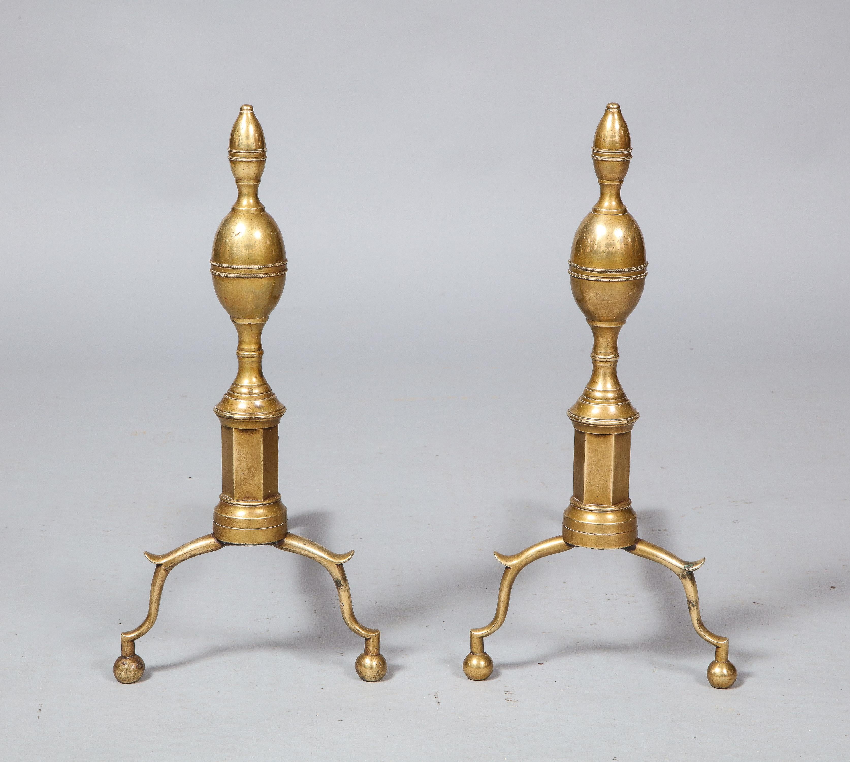 Good pair of early 19th century brass andirons having double lemon finials with ringed collars, over octagonal shafts and standing on scrolled legs with knee spurs and standing on ball feet, with original wrought iron supports.