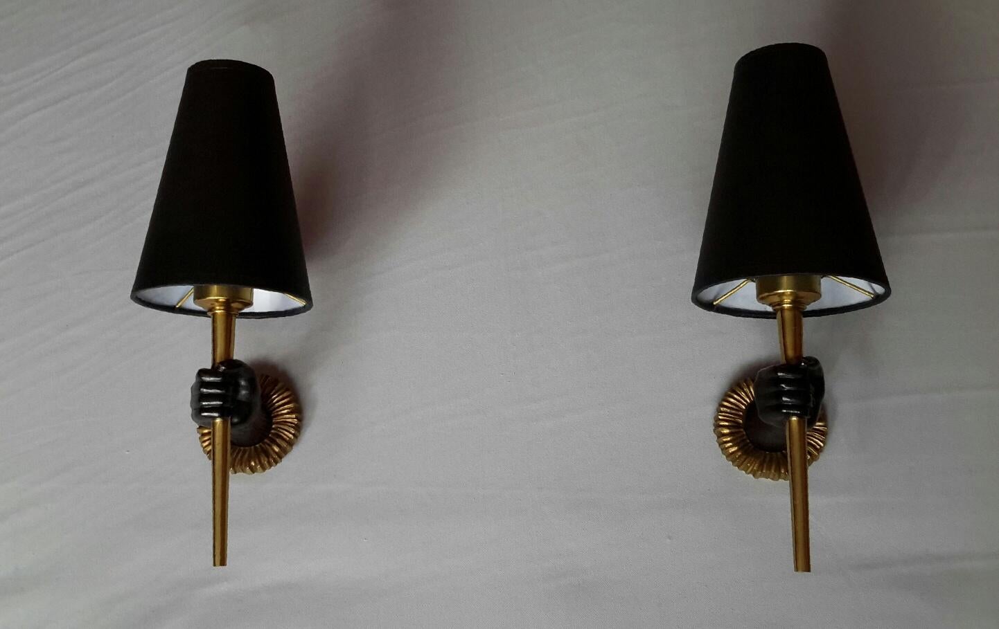 Beautiful pair of French neoclassical sconces from 1960 in gilded bronze and black patina by designer John Devoluy.
The pair is in an excellent condition, the electrical system has been renewed and comply with the US standard. The black cardboard