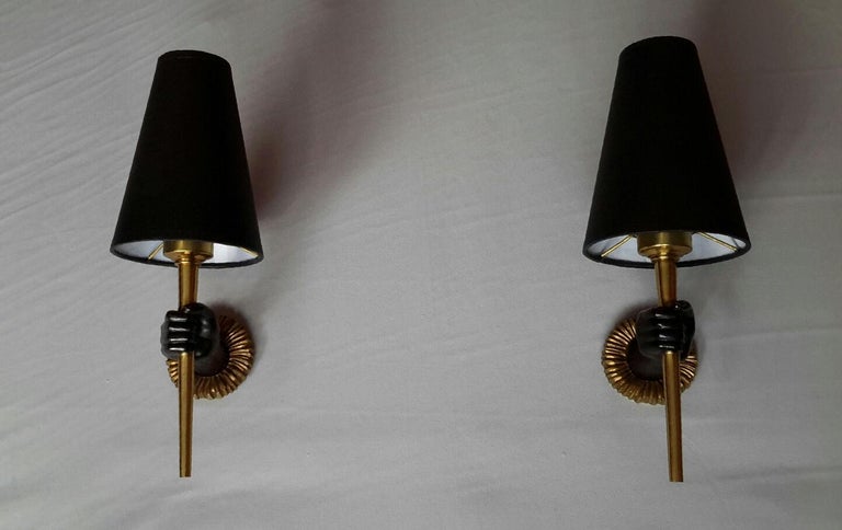 Beautiful pair of French neoclassical sconces from 1960 in gilded bronze and black patina by designer John Devoluy.
The pair is in an excellent condition, the electrical system has been renewed and comply with the US standard. The black cardboard