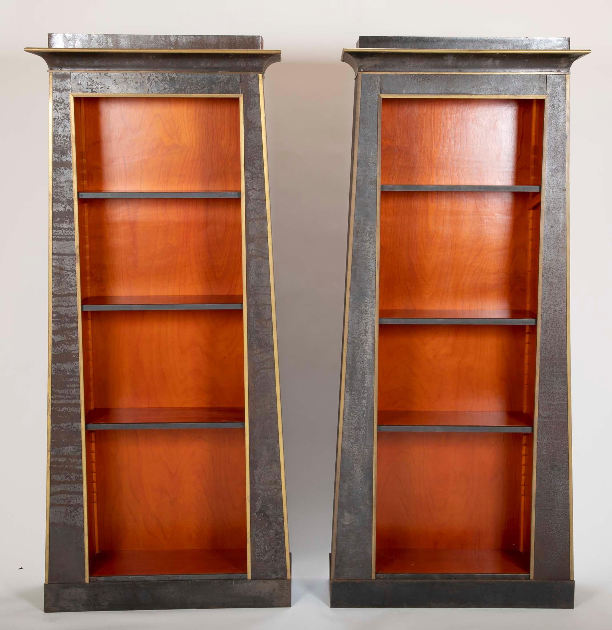 Stunning pair of unique custom made industrial neoclassical style bookshelves with iron over wood and brass trim. Each in the form of an ancient Egyptian doorway making for a very modern interpretation of the antique. With five adjustable shelves