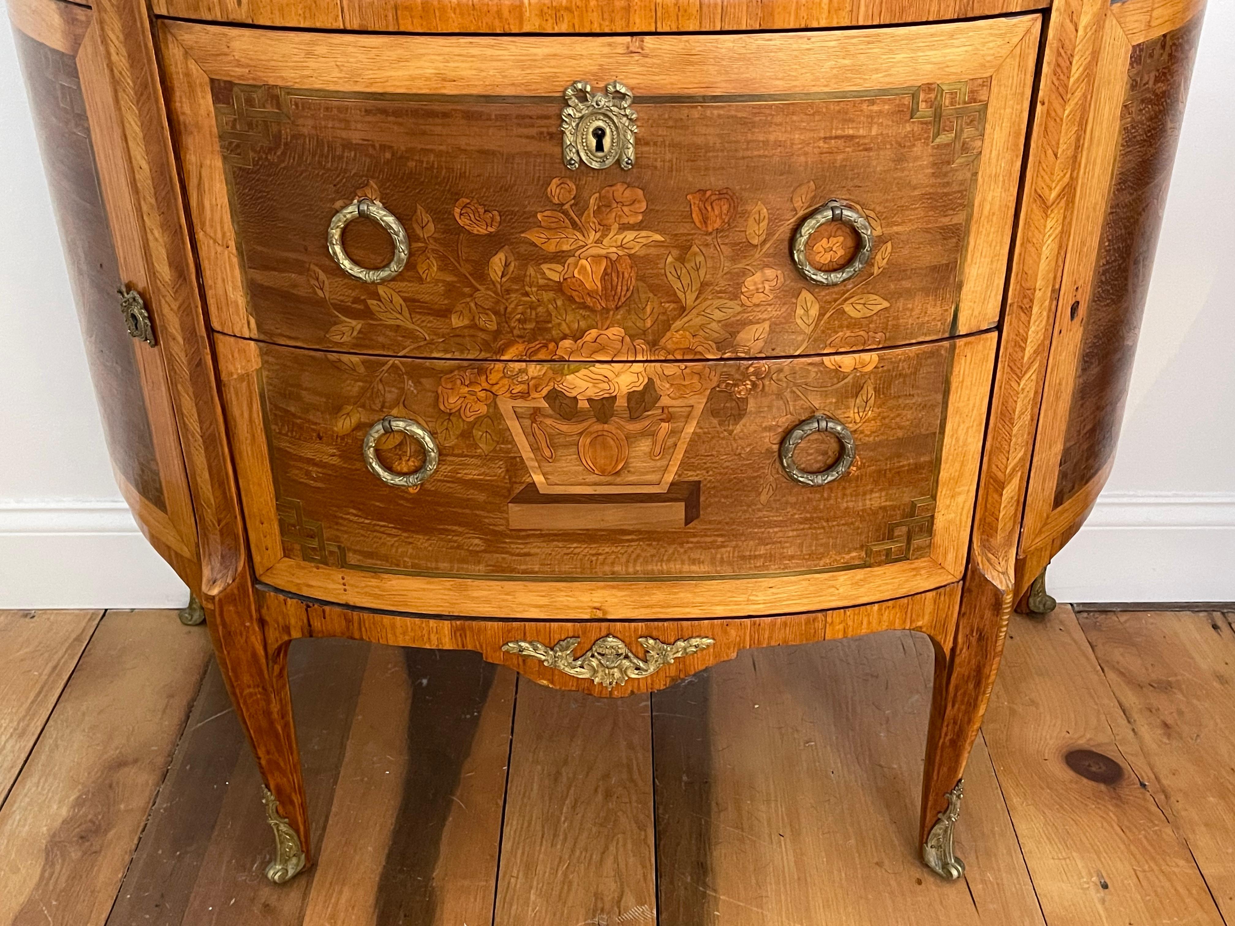 Pair of Continental Kingwood Marquetry Demilune commodes with marble tops. Beautifully inlaid with boxwood, tulipwood in neoclassical design. Original marble tops.