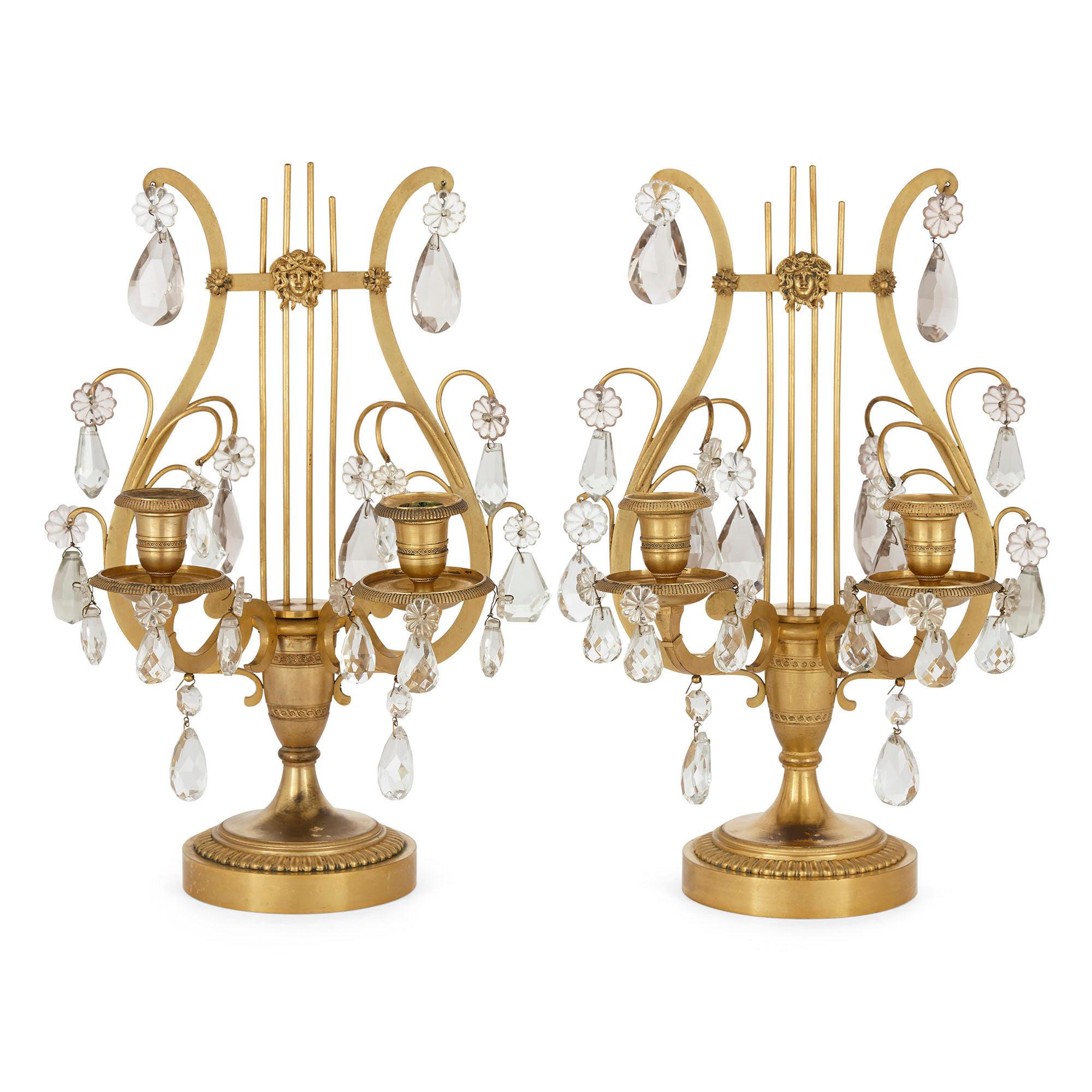 Pair of neoclassical Louis XVI style crystal and gilt bronze lyre candelabra,
French, 19th century
Dimensions: Height 40cm, width 26cm, depth 24cm

Inspired by the neoclassical Louis XVI style, this superb pair of ormolu table candelabra are
