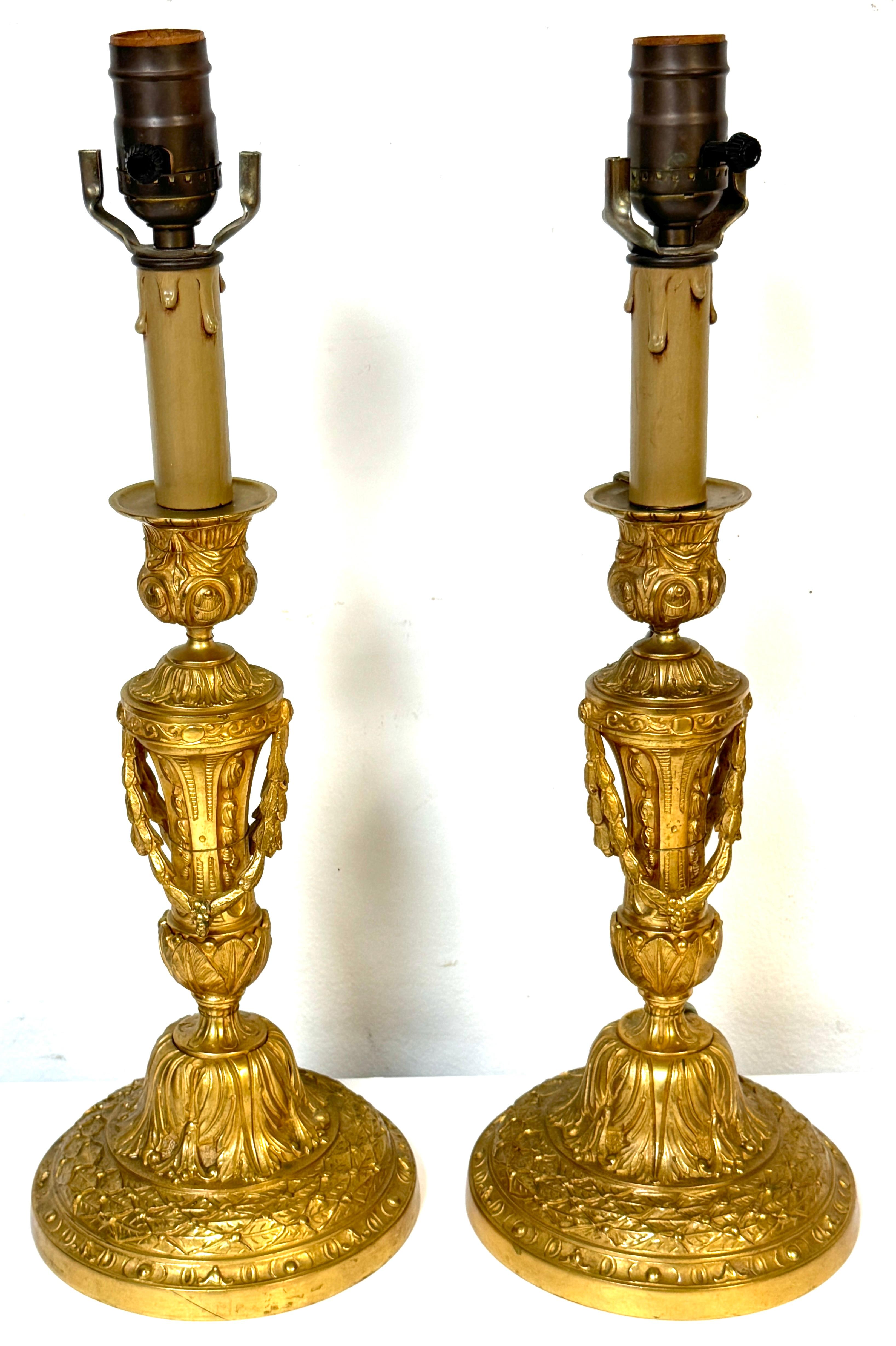 Pair of Neoclassical Louis XVI-Style Ormolu Candlesticks, Now as Lamps 
 with Laurel Swags and Acanthus Bases, Late 19th Century

A finely cast and richly detailed pair of French Louis XVI-style candlesticks, now adapted as table lamps, dating from