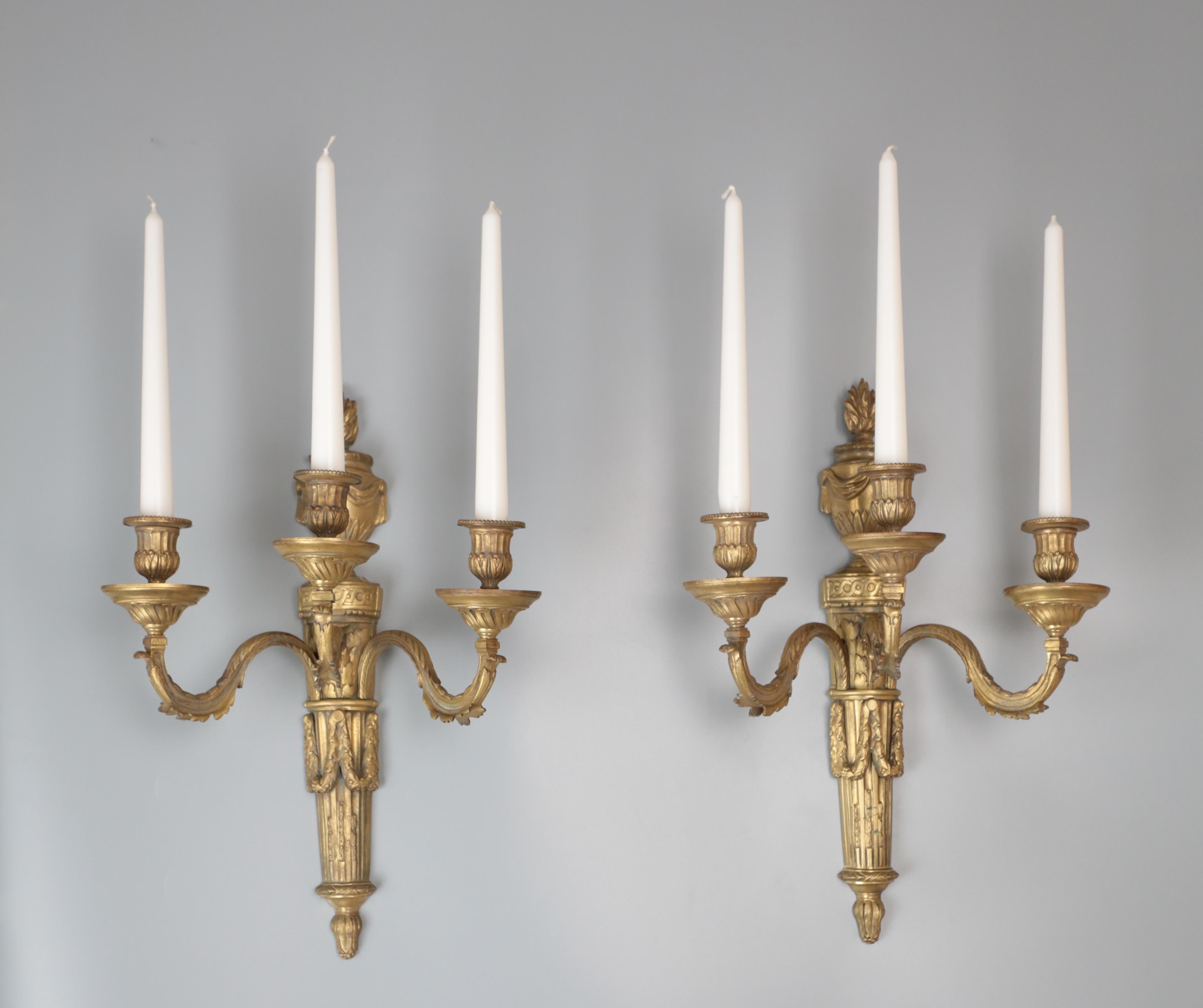 French gilded bronze wall lamps in the Adams style. Excellent quality of craftsmanship and material used. A typical classicist rendering with laurel leaves and a triumphal vase at the top. Lamps are very heavy. Date: around 1880. Provenance: France.