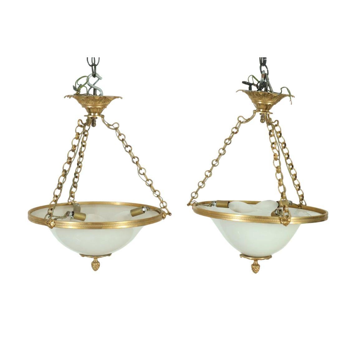 Questa raffinata coppia di pendenti neoclassici in ormolu e vetro lattimo unisce l'eleganza al design classico. Ogni pendente è caratterizzato da una forma a ombrello rovesciato, realizzata in vetro liscio e smerigliato che diffonde la luce in modo