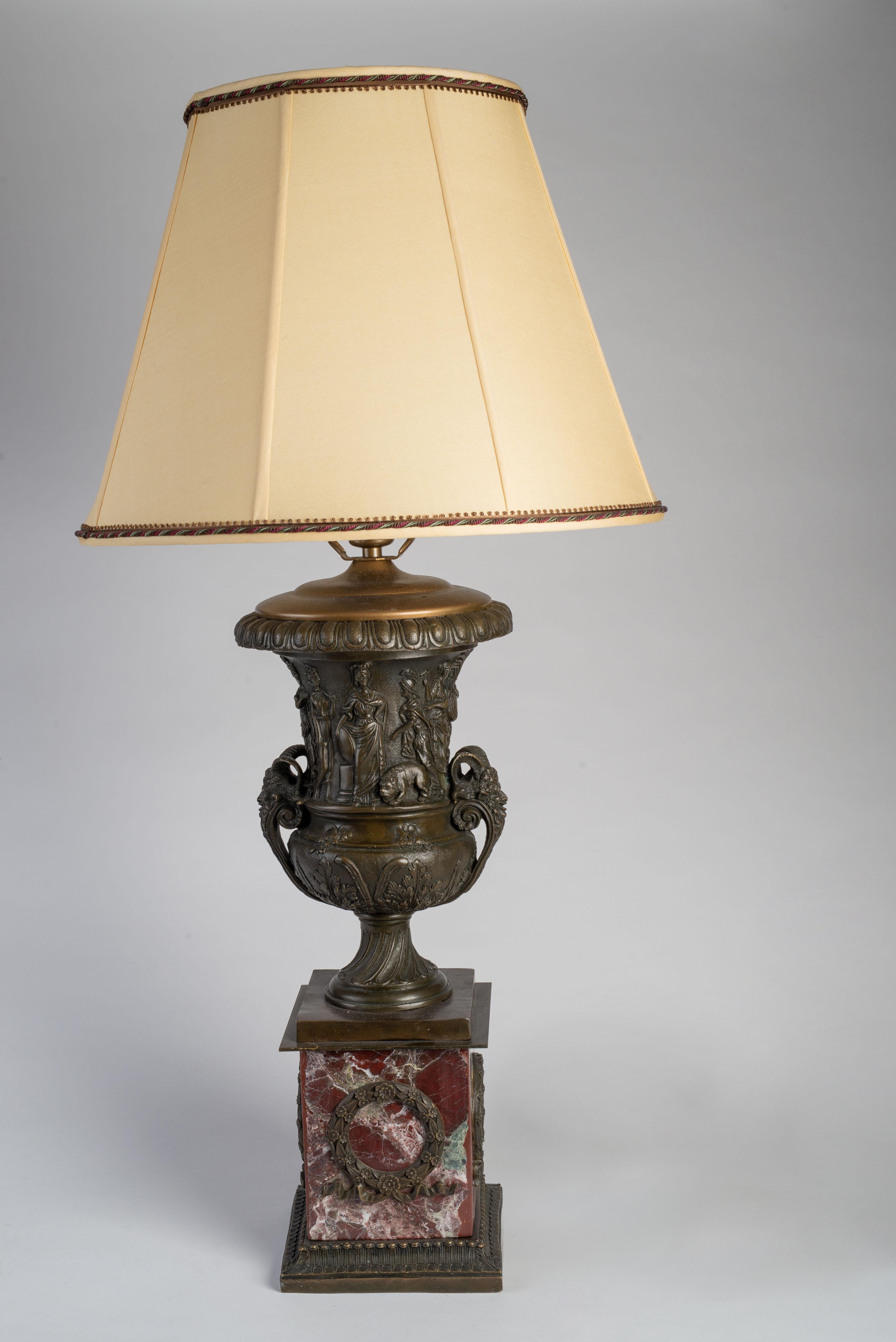 Each urn cast with frieze of classical figures, raised on a bronze-mounted rouge griotte square marble base. The lampshades are silk and custom made by Blanche Field.

Dimensions include lampshade. The height of the base only (urn on marble stand)