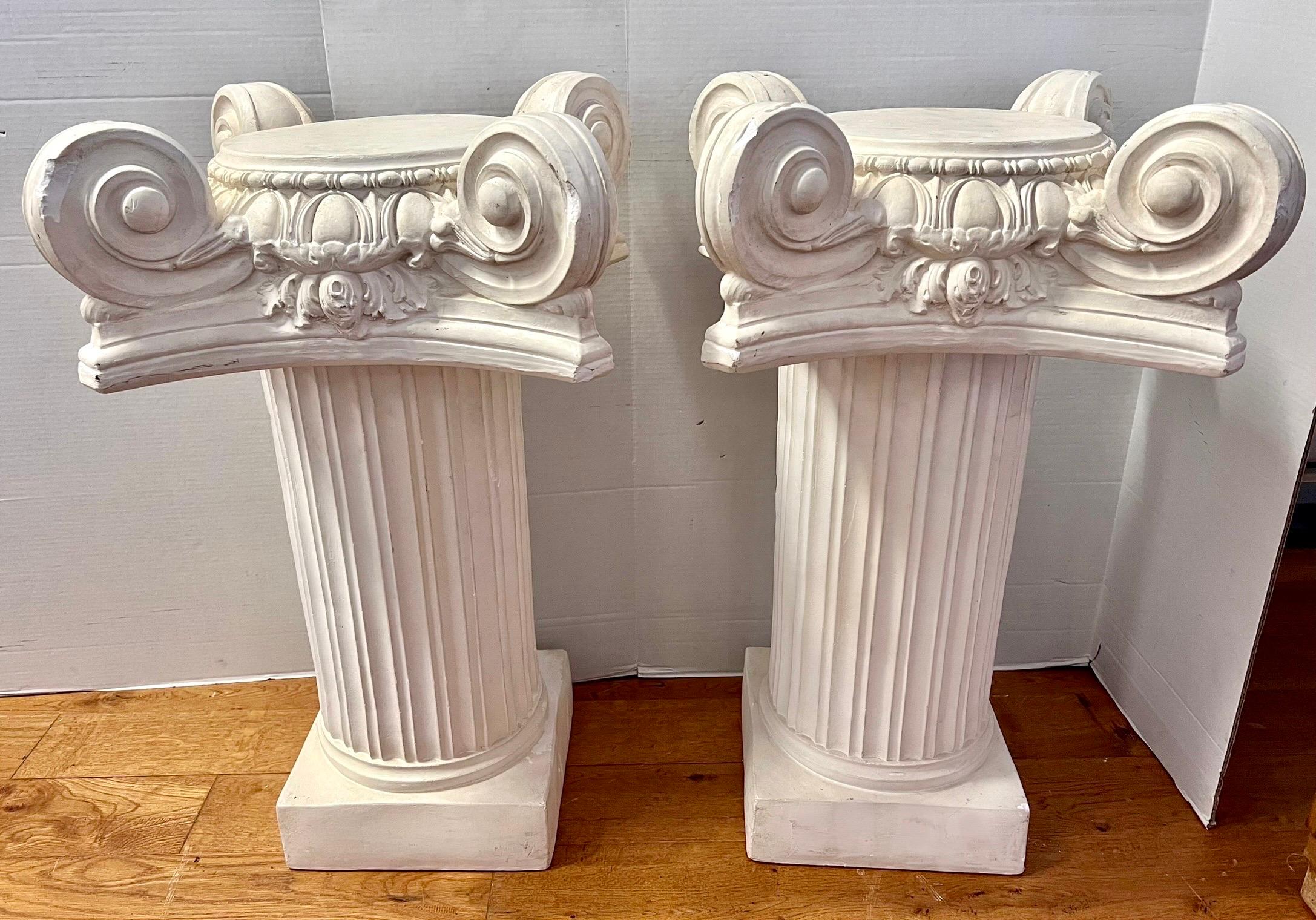Pair of large heavy plaster iconic columns or side tables  multi-purpose.  Each has two pieces with top portion of column coming off for ease of movement.