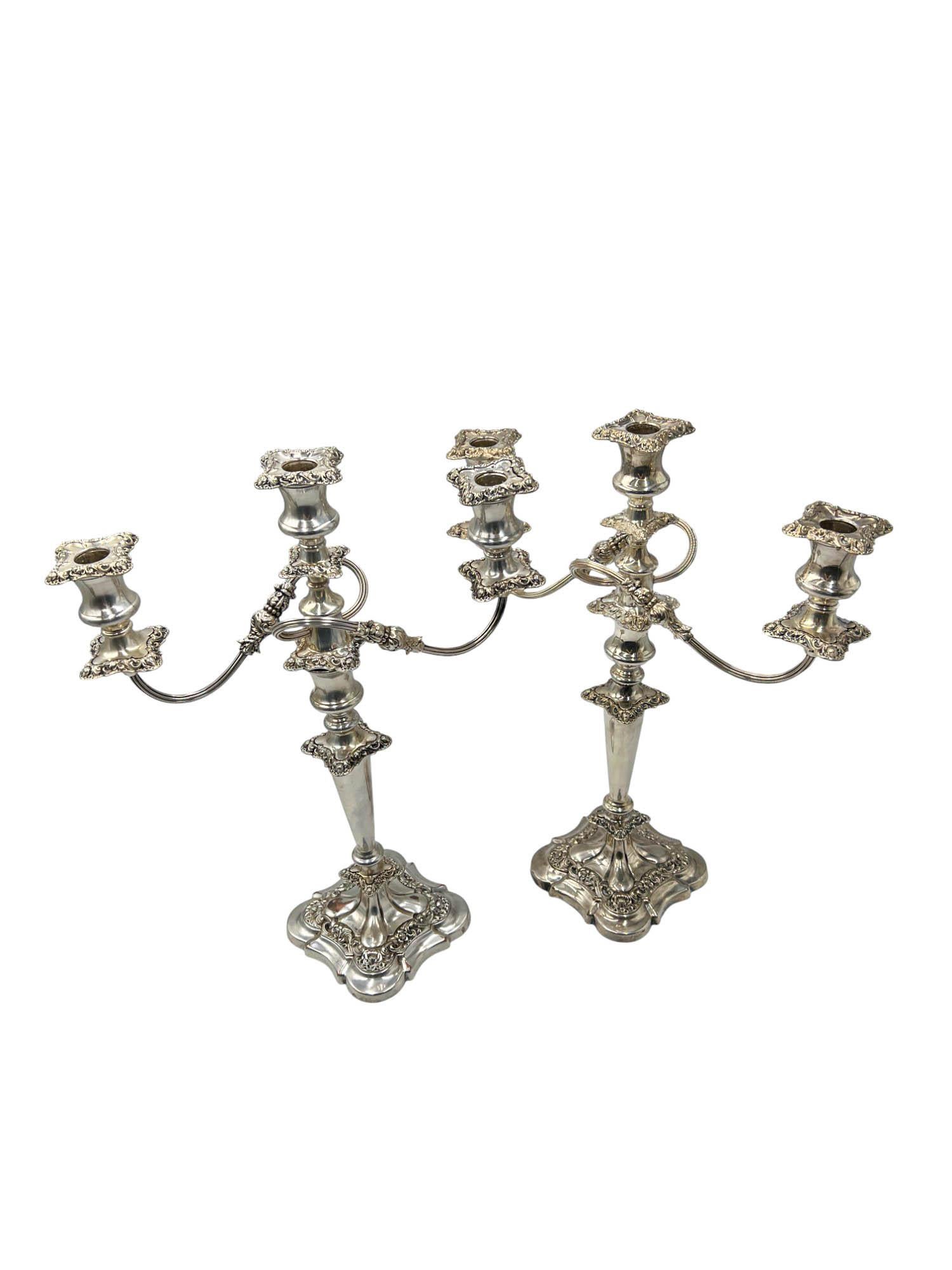 Questa coppia di candelabri a tre luci riflette l'estetica raffinata del movimento Neoclassical Revival dell'inizio del XX secolo. Ogni pezzo reca il timbro 