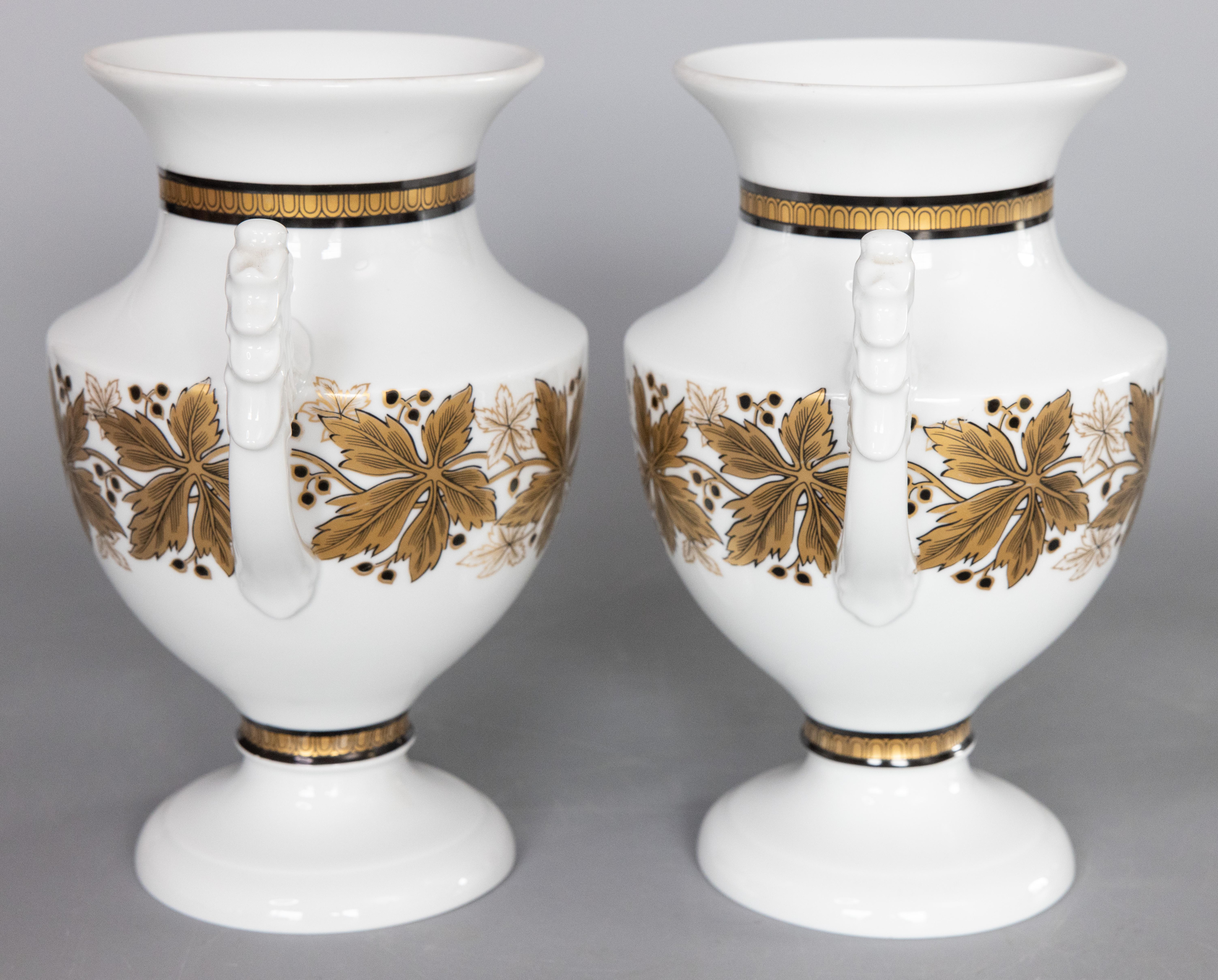 A lovely pair of vintage German porcelain white and gold urns or vases from the Royal Tettau Manufactory, circa 1930-1950. Maker's mark on reverse. These gorgeous vases have a stylish Neoclassical design with ornamental eagle handles and gilt leaf