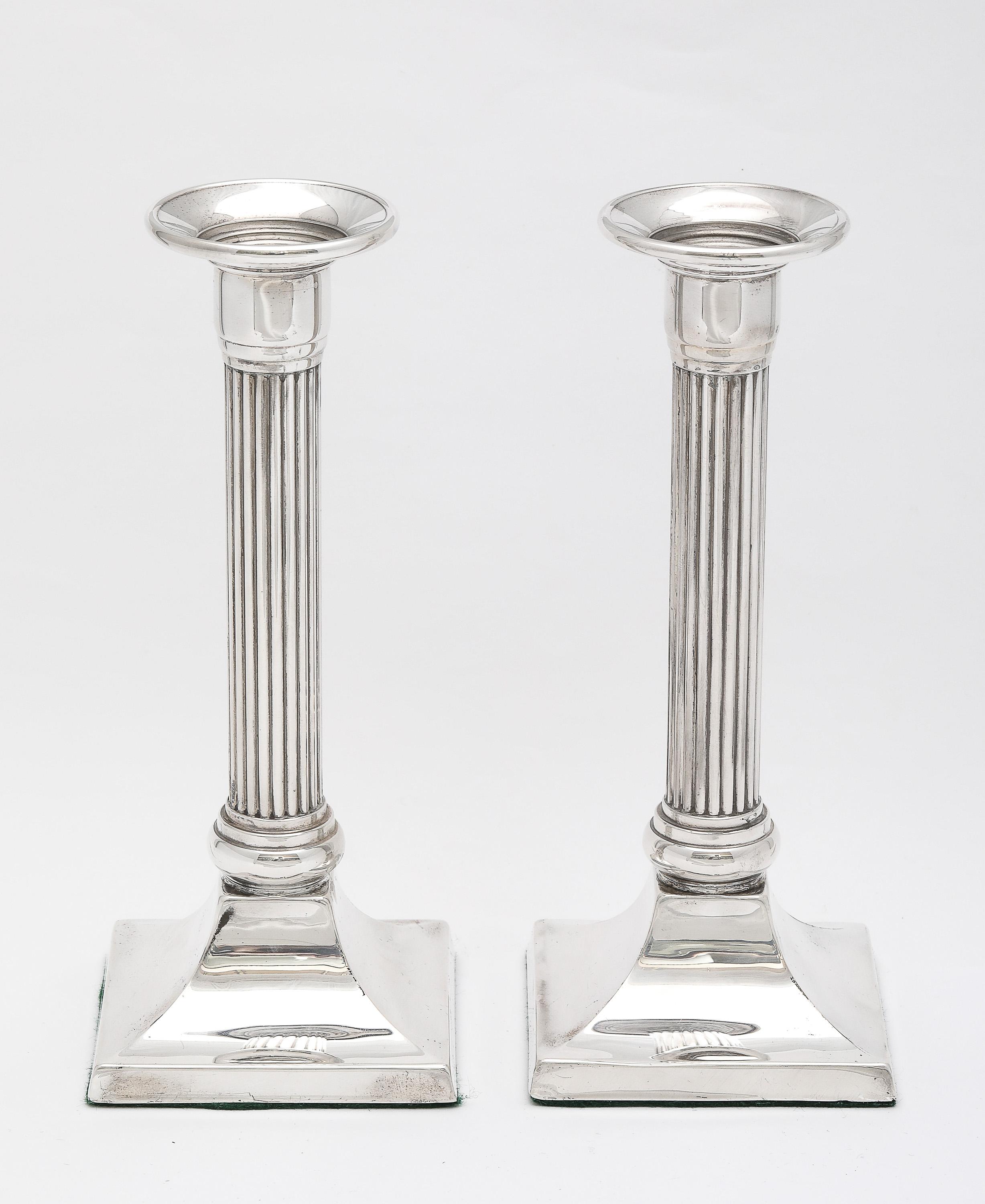 Pareja de candelabros de plata de ley, de estilo neoclásico, con columna de base cuadrada, estadounidenses, ca. 1930's. Cada candelabro mide 7 1/8 pulgadas de alto x 3 pulgadas de ancho (en el punto más ancho de la base) x 3 pulgadas de profundidad