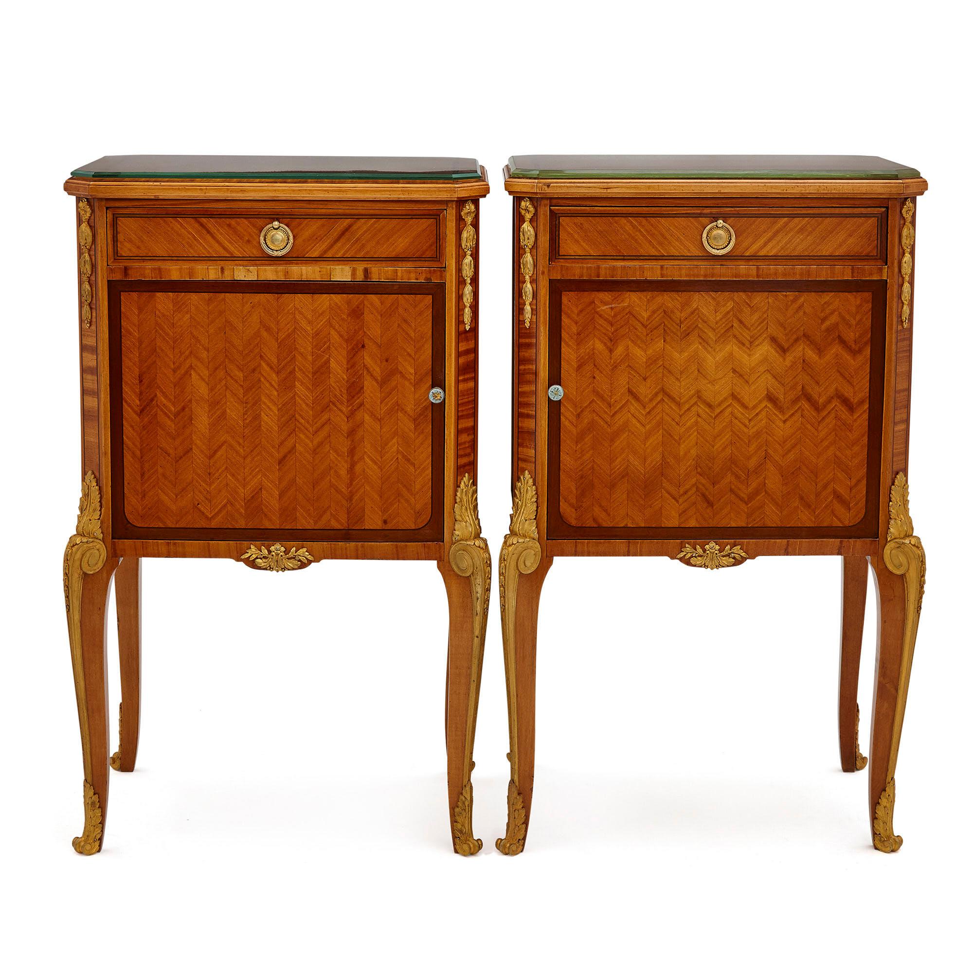 Pair of neoclassical style bedside cabinets retailed by Au Gros Chêne
French, late 19th century
Dimensions: Height 83cm, width 50cm, depth 35cm

Designed in the refined Neoclassical style, this pair of bedside cabinets are crafted from hardwood