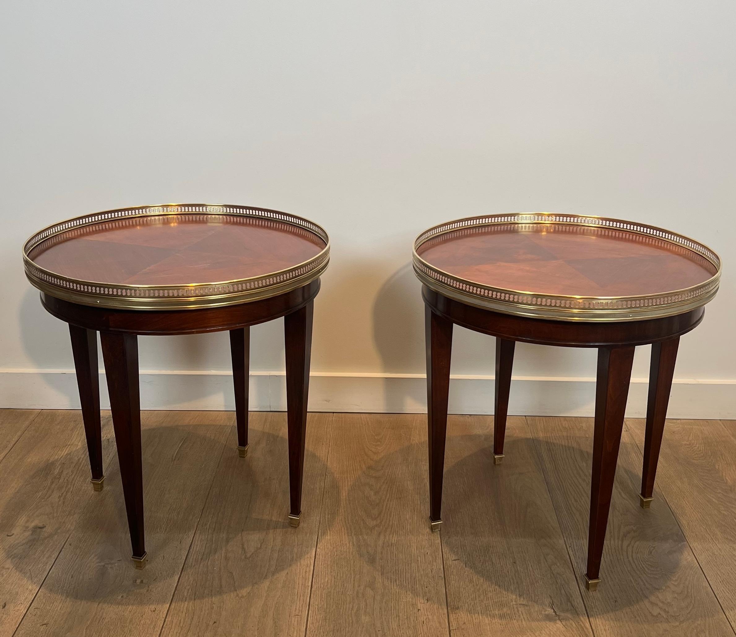 This nice and elegant pair of neoclassical style bouillotte tables, round side tables or gueridons is made of wood and brass. This is a French work. Circa 1940