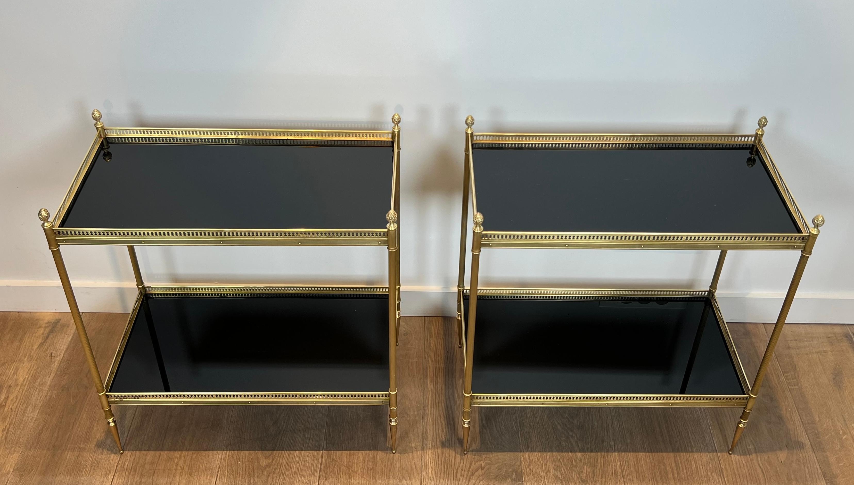 This very nice pair of neoclassical style side tables is made of brass with black lacquered tops surrounded by an openwork gallery. This is a French work by Maison Jansen. Circa 1940