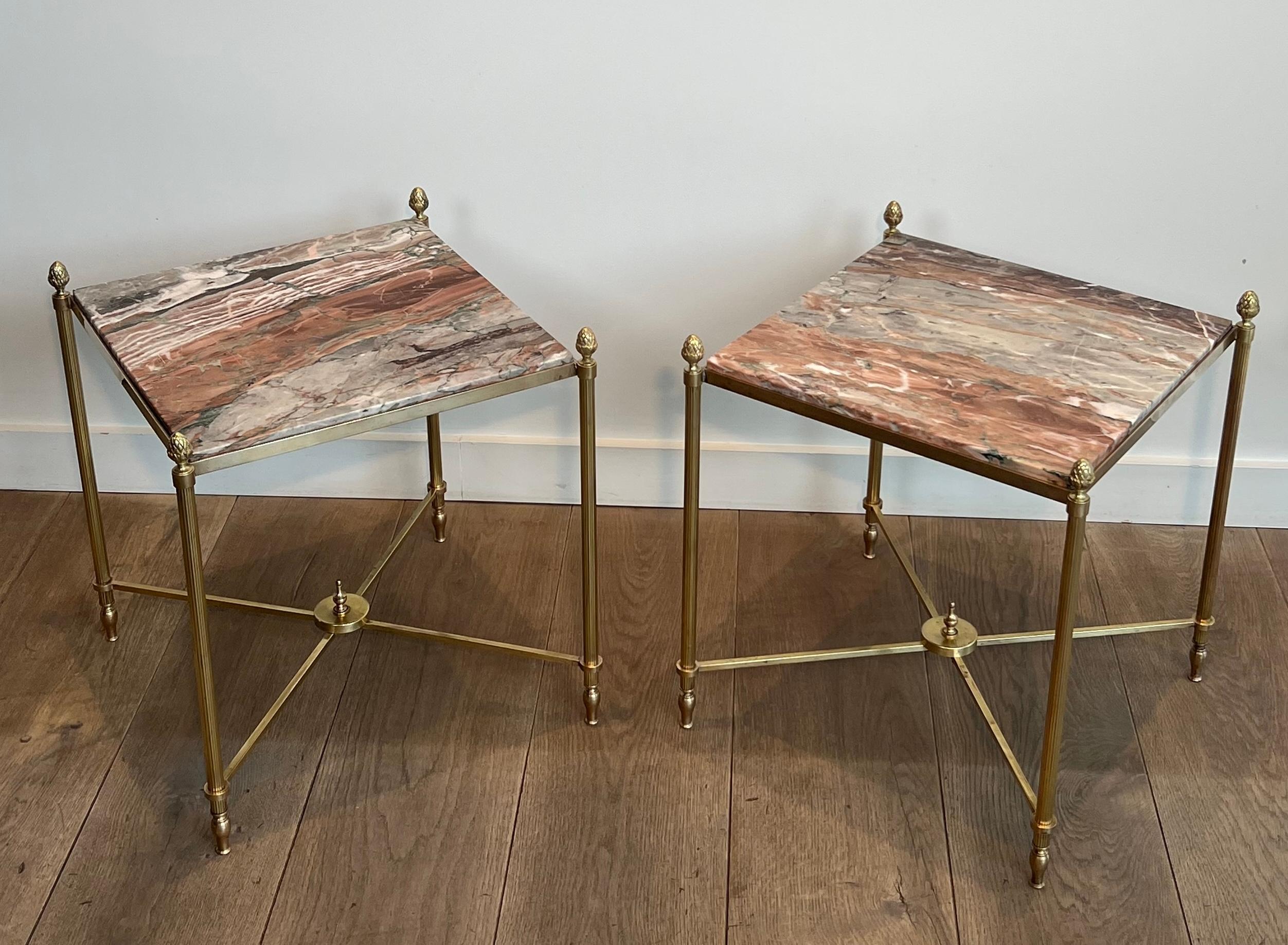 This very nice and elegant pair of neoclassical style side tables is made of brass with fluted legs joined by a spacer, the legs topped with a fine pineapple finial on each corner and a beautiful marble on top. This is a French work by Maison