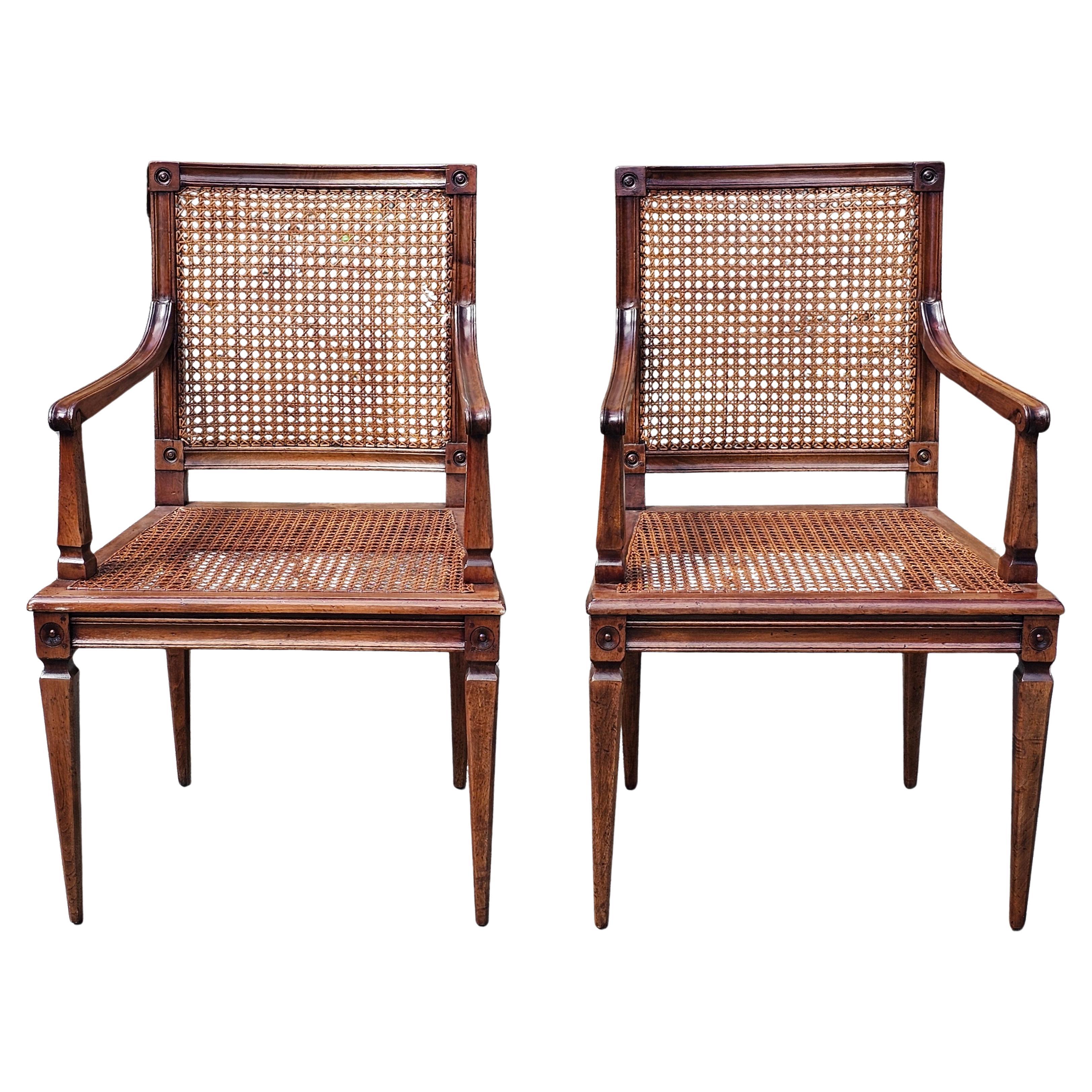 Pair of Neoclassical Style Caned Seat and Back Patinated Walnut Arm Chairs