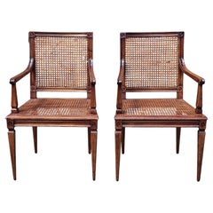 Paire de chaises à accoudoirs de style néoclassique à assise et dossier cannelés en noyer patiné