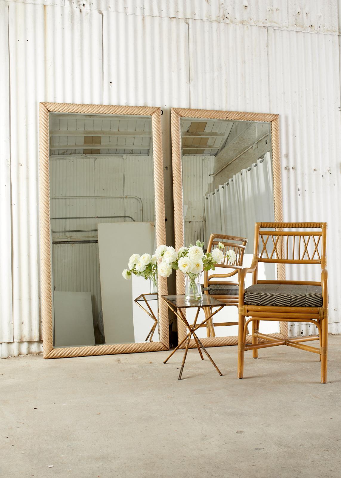 Stunning pair of large floor mirrors featuring a hand-carved nautical style rope design. The thick frames have an intentionally aged and distressed patina on the finish which features cerused style paint remnants. The frames are inset with