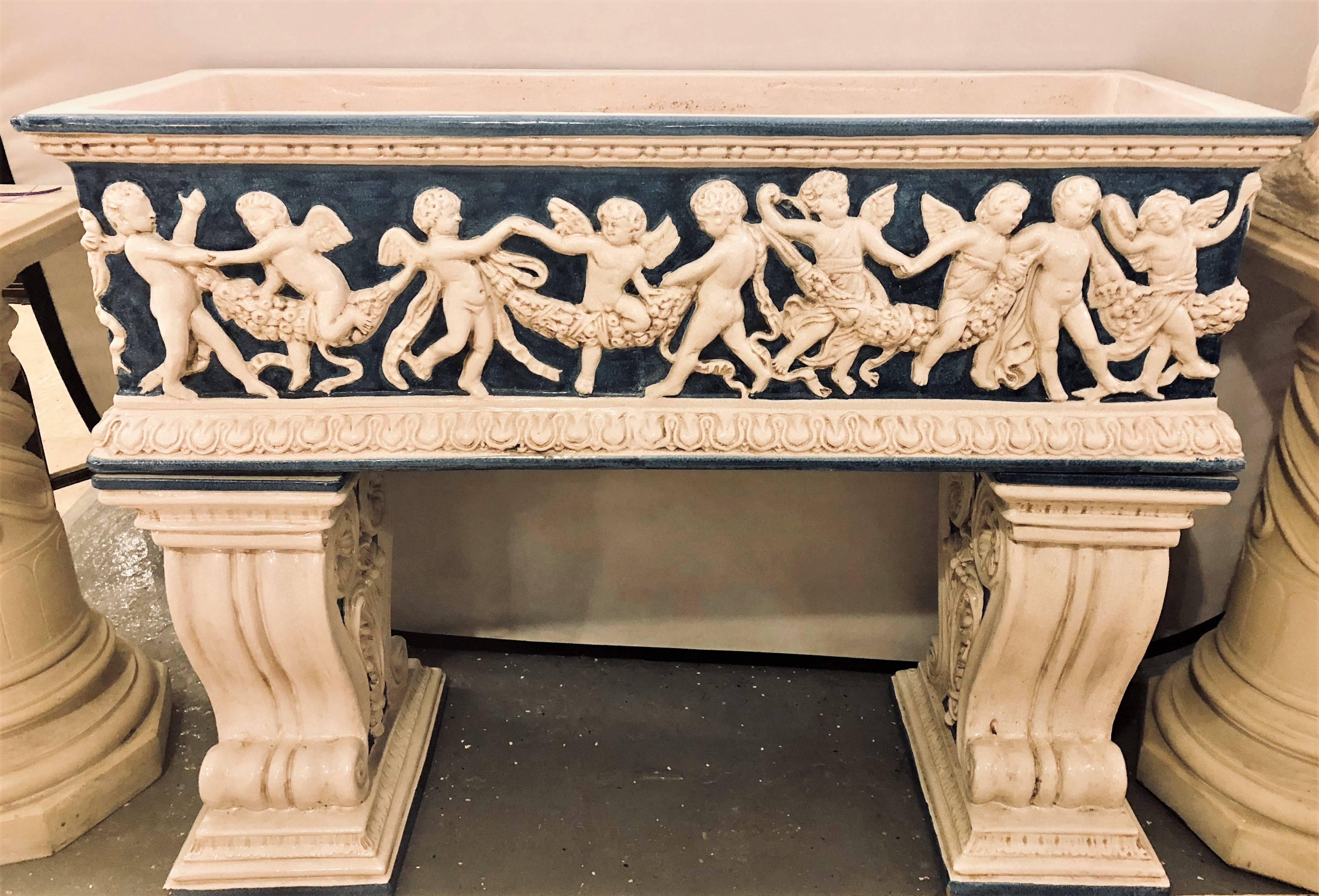 A pair of ceramic planter tops depicting cherubs dancing (one lacking pedestals bases). These freestanding planter tops can be used on their own or stand on any pedestals. Pedestals seen are for one jardinare only. These are simply stunning in a