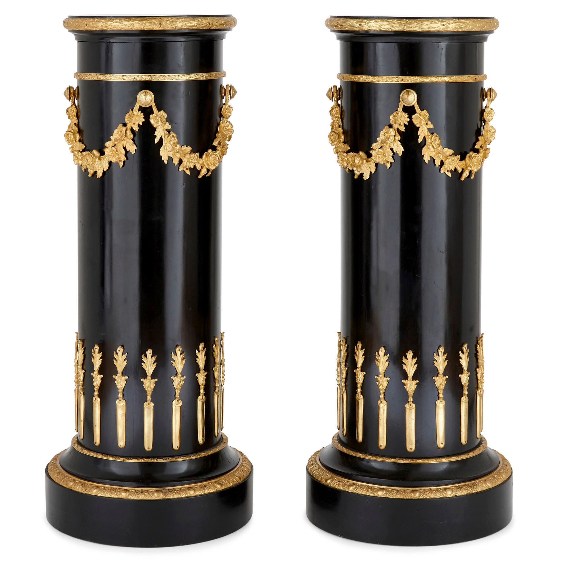 Pair of neoclassical style gilt bronze and ebonized wood stands
French, late 19th century
Measures: Height 110cm, diameter 46cm

This fine pair of stands is crafted from ebonized wood mounted with gilt bronze. The stands resemble truncated