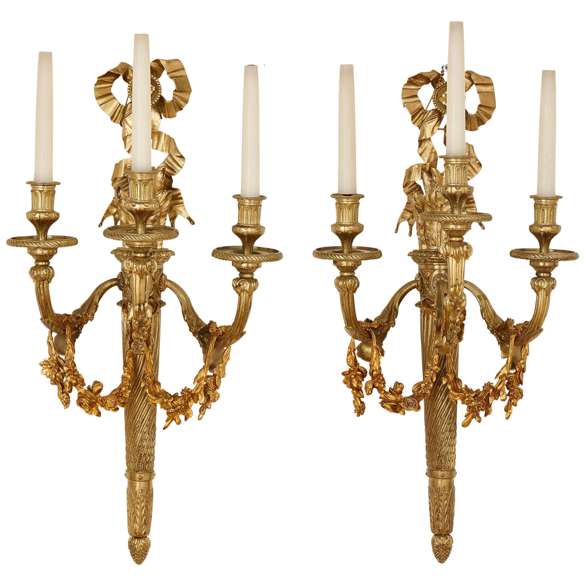 Paire d'appliques à trois lumières de style néoclassique en bronze doré en vente