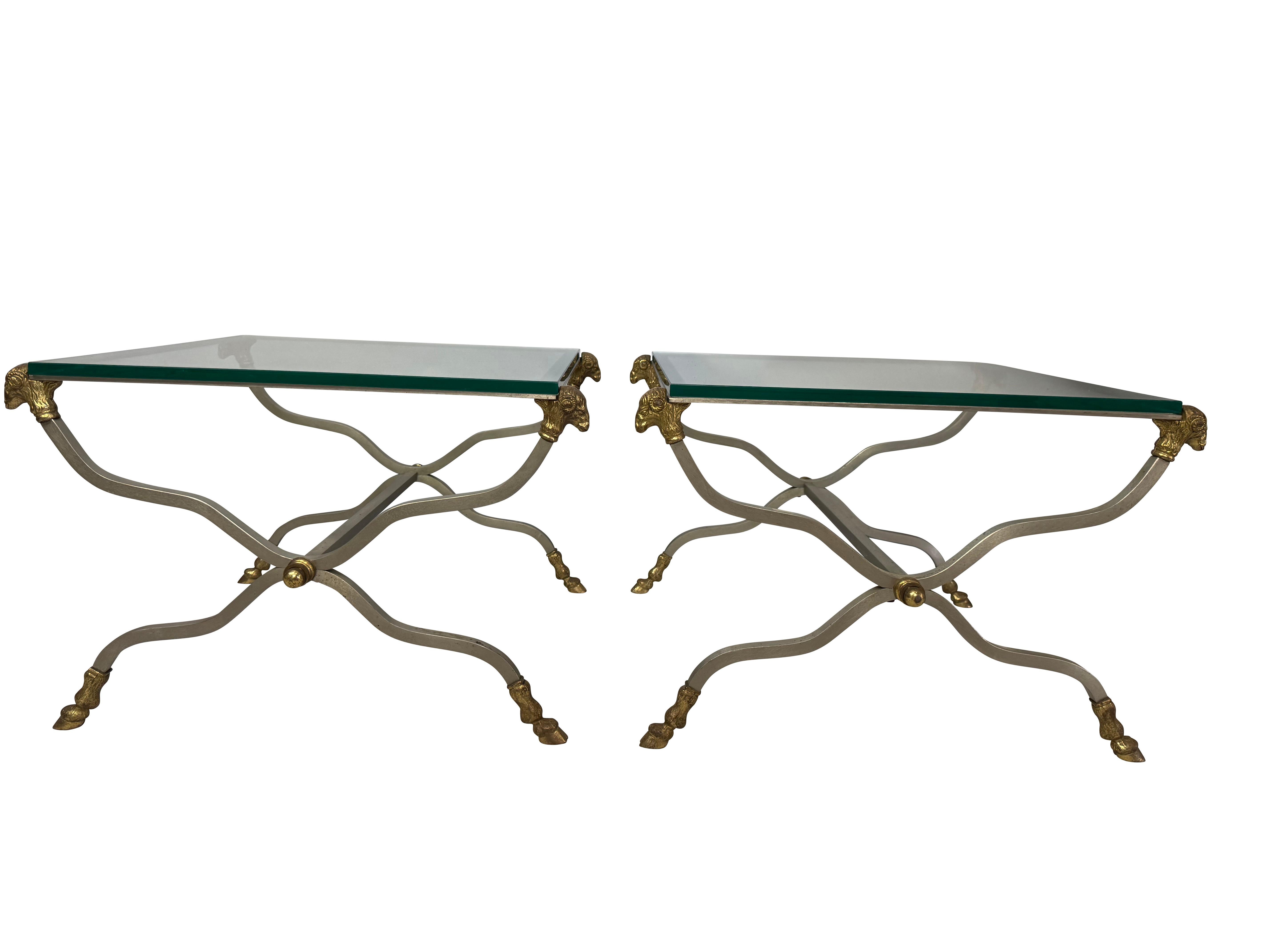 Pareja de mesas de centro con tapa de cristal de estilo neoclásico
Cada una con una tapa rectangular de cristal biselado apoyada en una base de metal pintado en forma de X, unida por un rosetón central dorado, las esquinas con monturas de bronce
