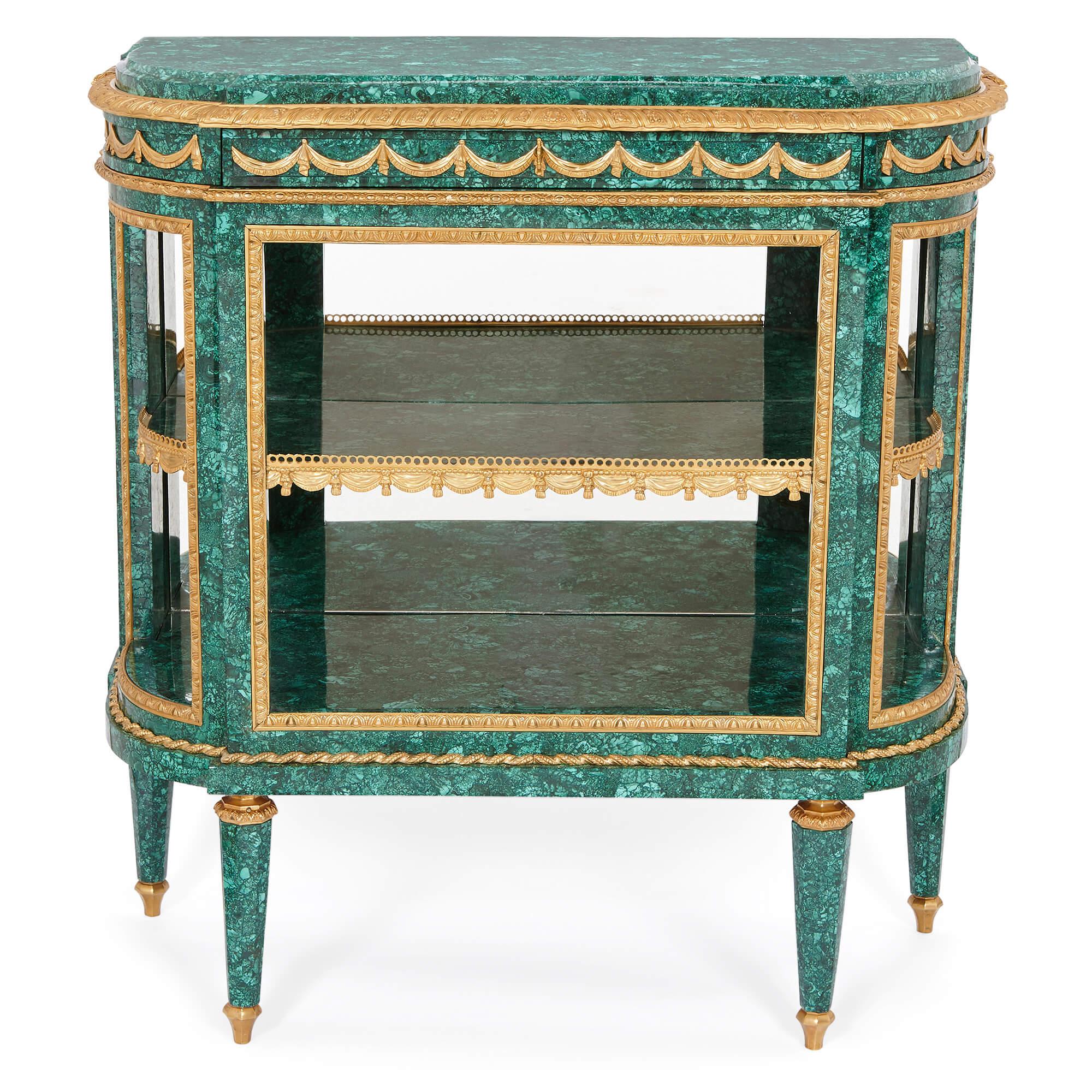Pair of Neoclassical style malachite and gilt bronze commodes
French, 20th century
Measures: Height 87cm, width 84cm, depth 38cm

This superb pair of neoclassical style console tables is wrought from malachite, gilt bronze, and mirror—the