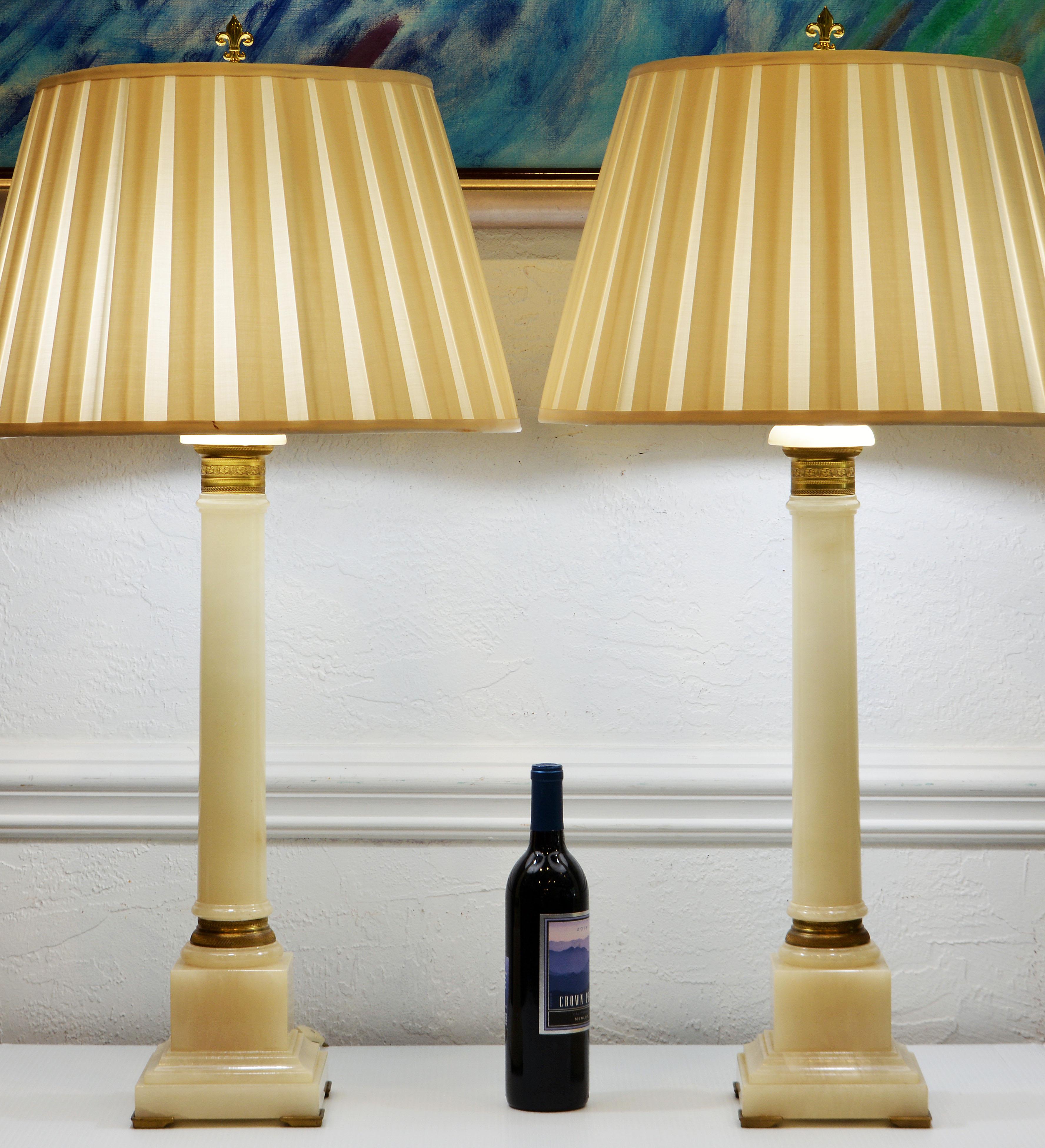 This rare pair of bronze mounted neoclassical style Onyx lamps by the legendary Marbro Lamo Company are stunningly elegant with a slight modern air to the design. The bronze mounts are engraved with fetching patterns. The columns rest on stepped