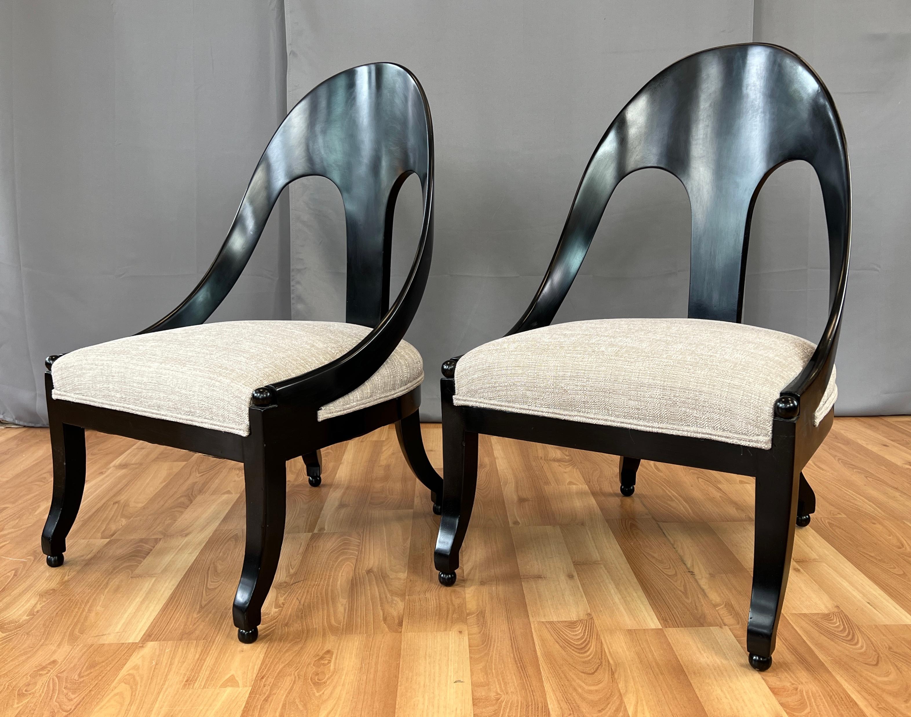 Offered here is a pair of neoclassical style spoon back slipper chairs designed by Michael Taylor for Baker Furniture.
Black frames with beige upholstery that feels to be a heavy cotton blend. Upholstery looks to be new, foam feels great so I