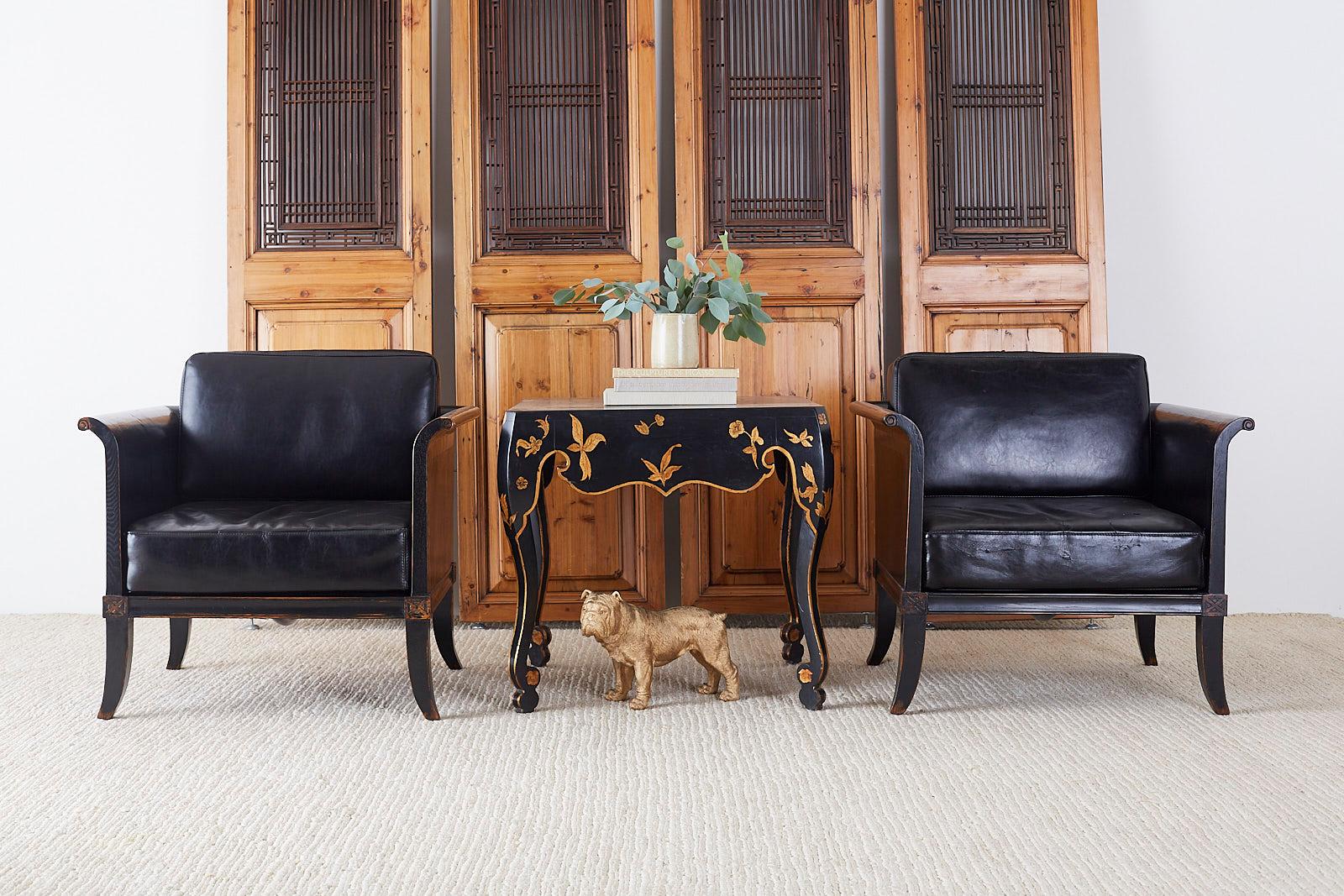 Dramatic pair of oak lacquered cube chairs or club chairs made in the neoclassical style. Features a distressed black lacquer wood finish with a low sleek profile. The arms and back have scrolled ends and the seat is fitted with thick, faux leather