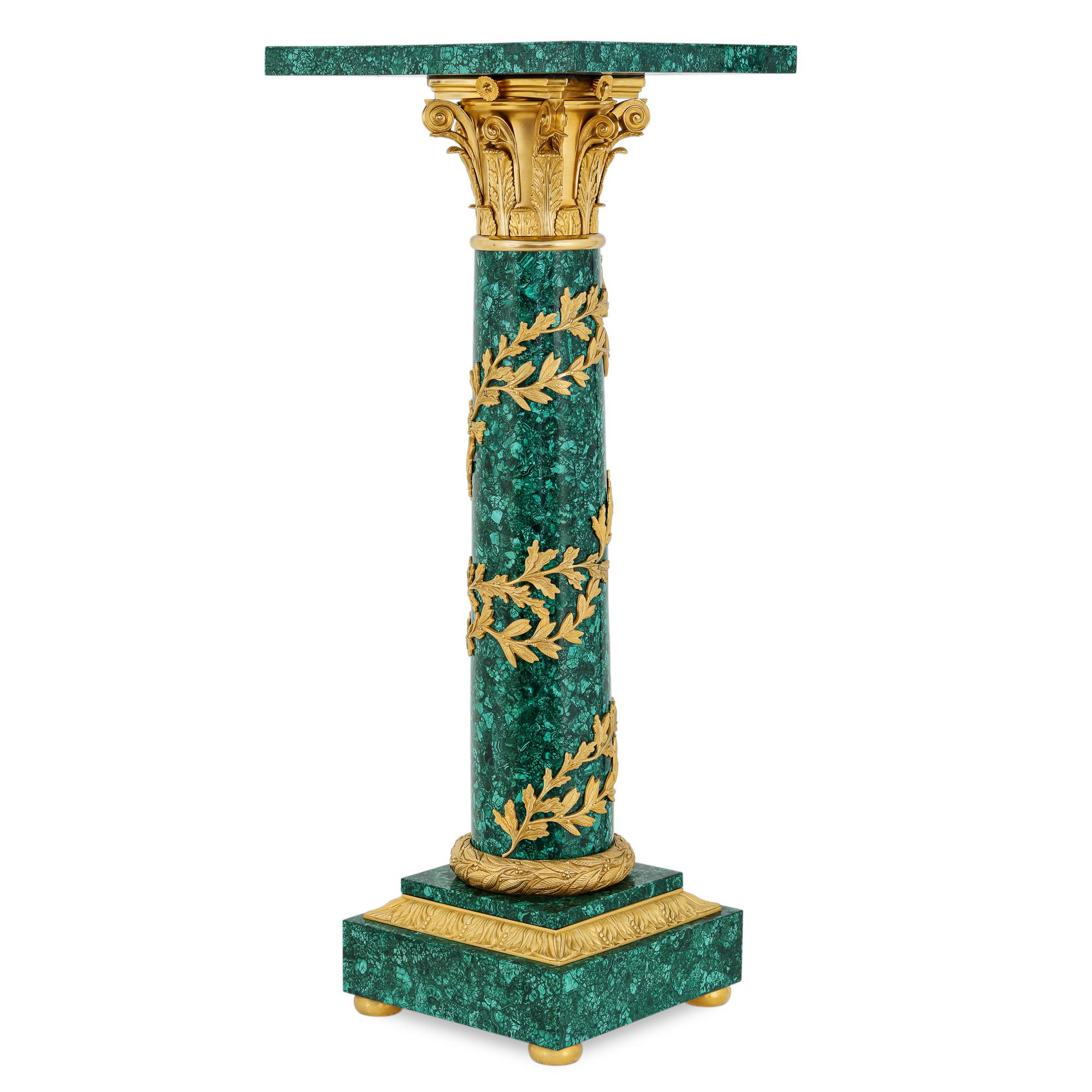 Magnificent pair of neoclassical style gilt bronze Mounted Malachite Columns highlighted with Ormolu foliage Wrapped around the Main body of the columns in a circular fashion. These columns were crafted in the style of Louis XV1 circa 18 century.