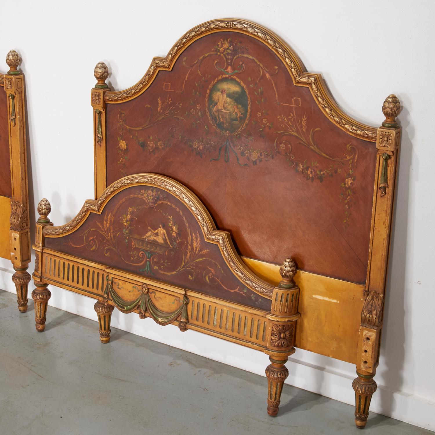 Un'impressionante coppia di letti gemelli in stile neoclassico, ciascuno finemente dipinto a mano con ghirlande, motivi fogliati a scorrimento e medaglioni centrali raffiguranti figure classiche in scene pastorali. Realizzati in impiallacciatura di